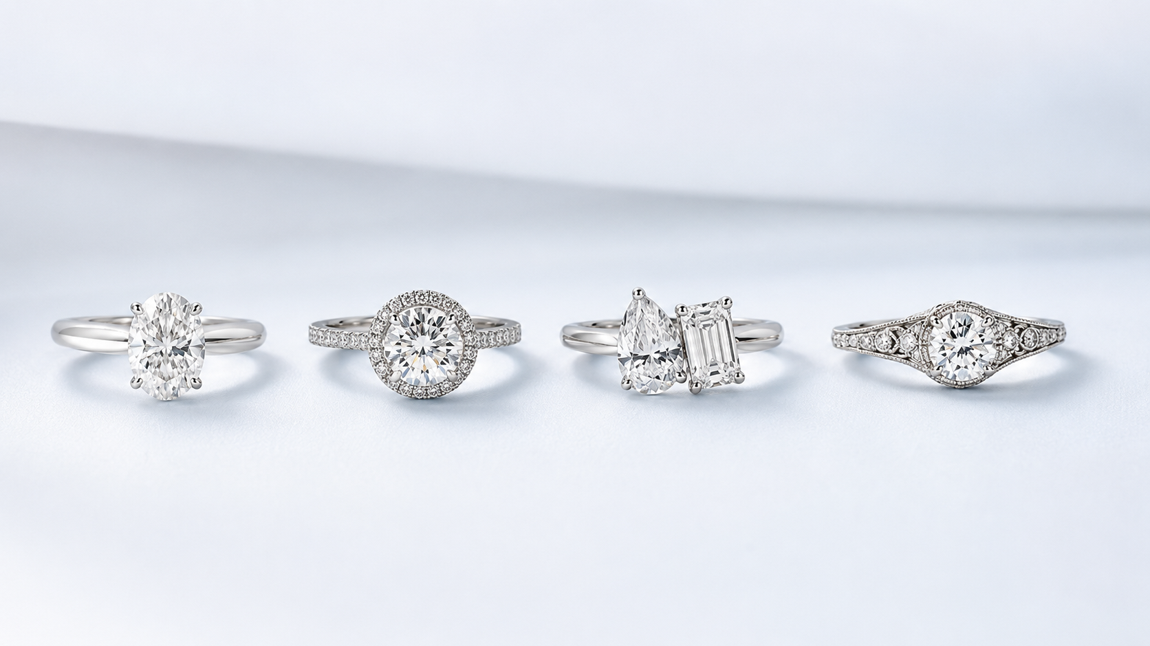 Four realistic diamond engagement rings on a soft white background