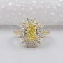 Gold ring with a yellow diamond and smaller diamonds on a white background

