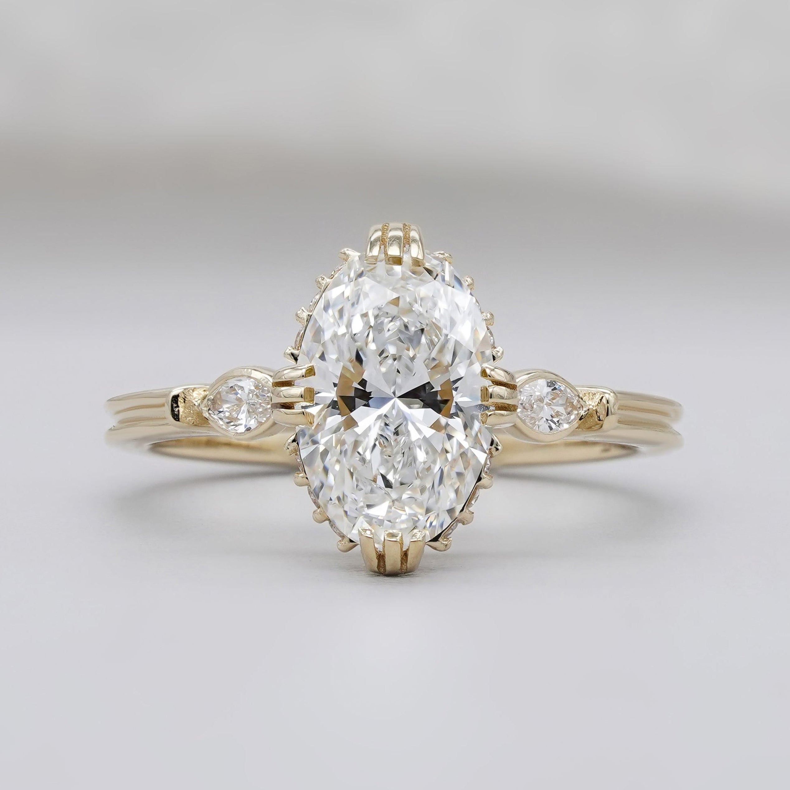 Oval diamond engagement ring with three stones in yellow gold