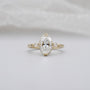 Oval diamond engagement ring with three stones in yellow gold