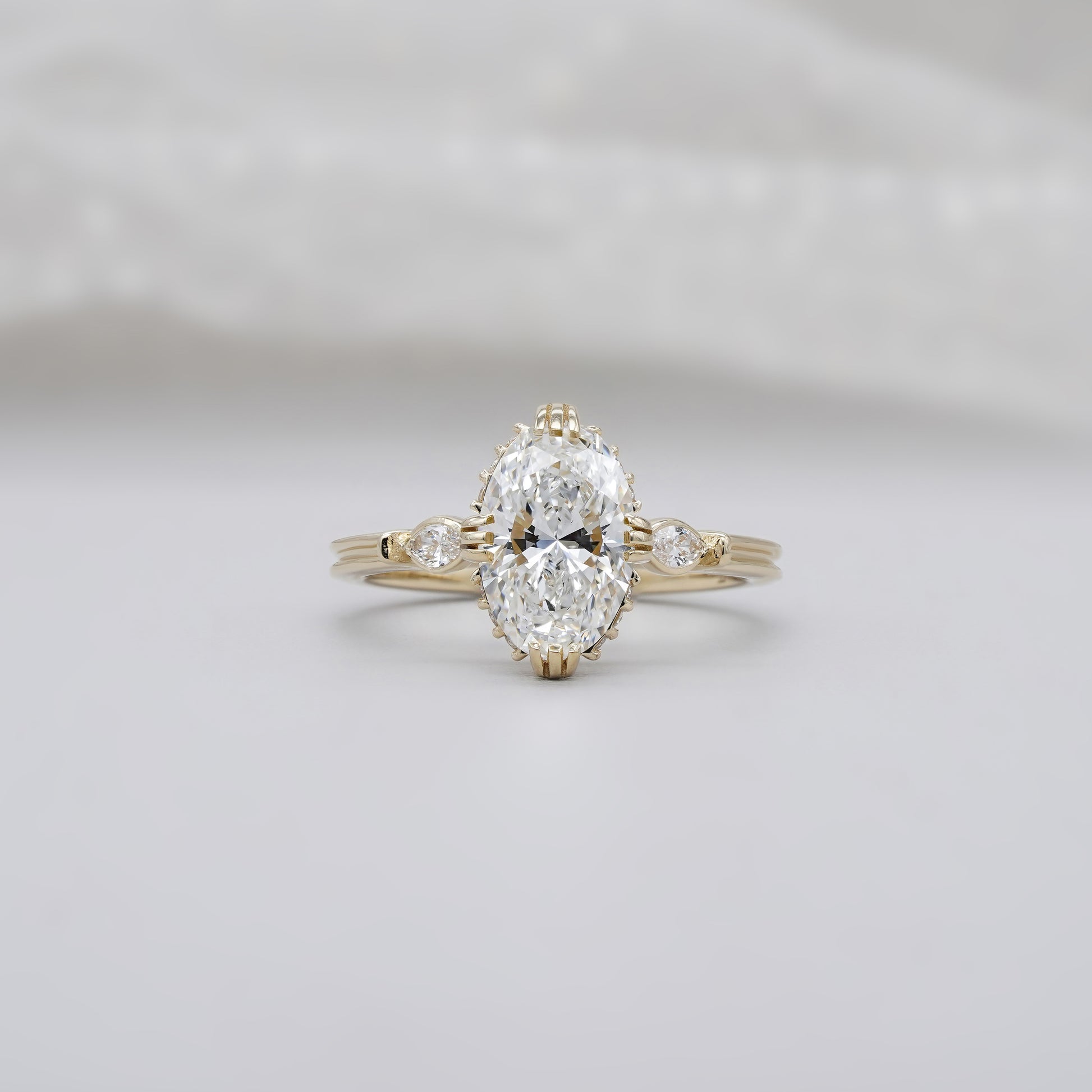 Oval diamond engagement ring with three stones in yellow gold