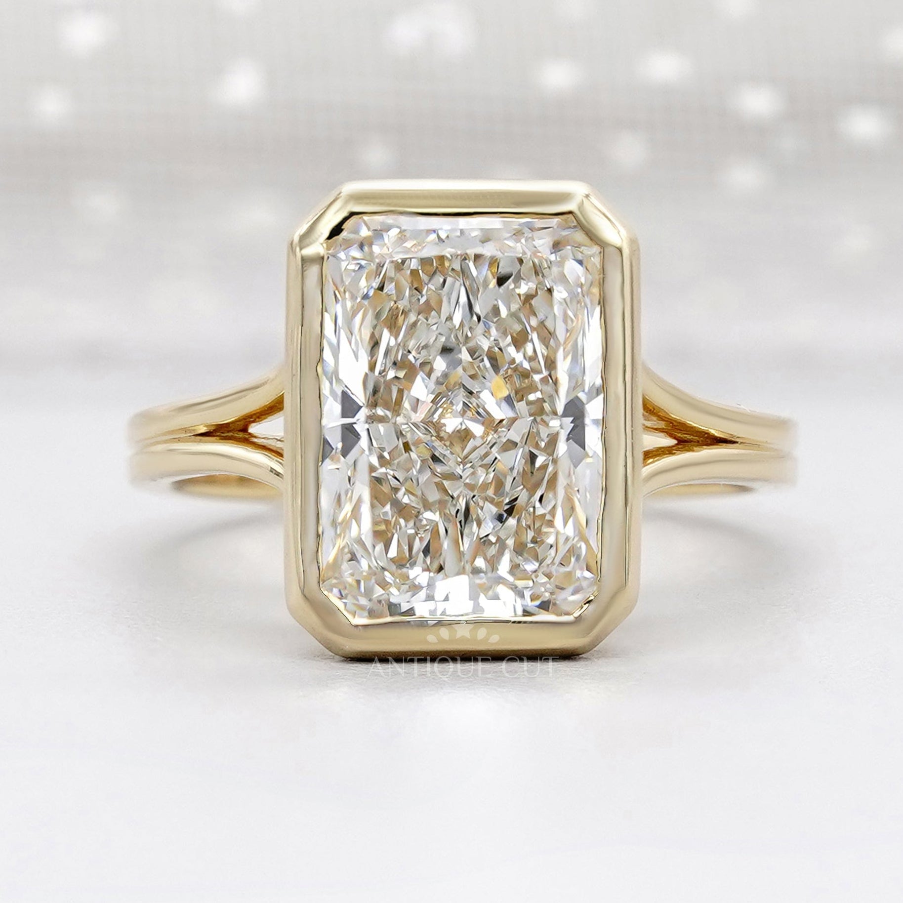 Bezel set radiant cut engagement ring in yellow gold