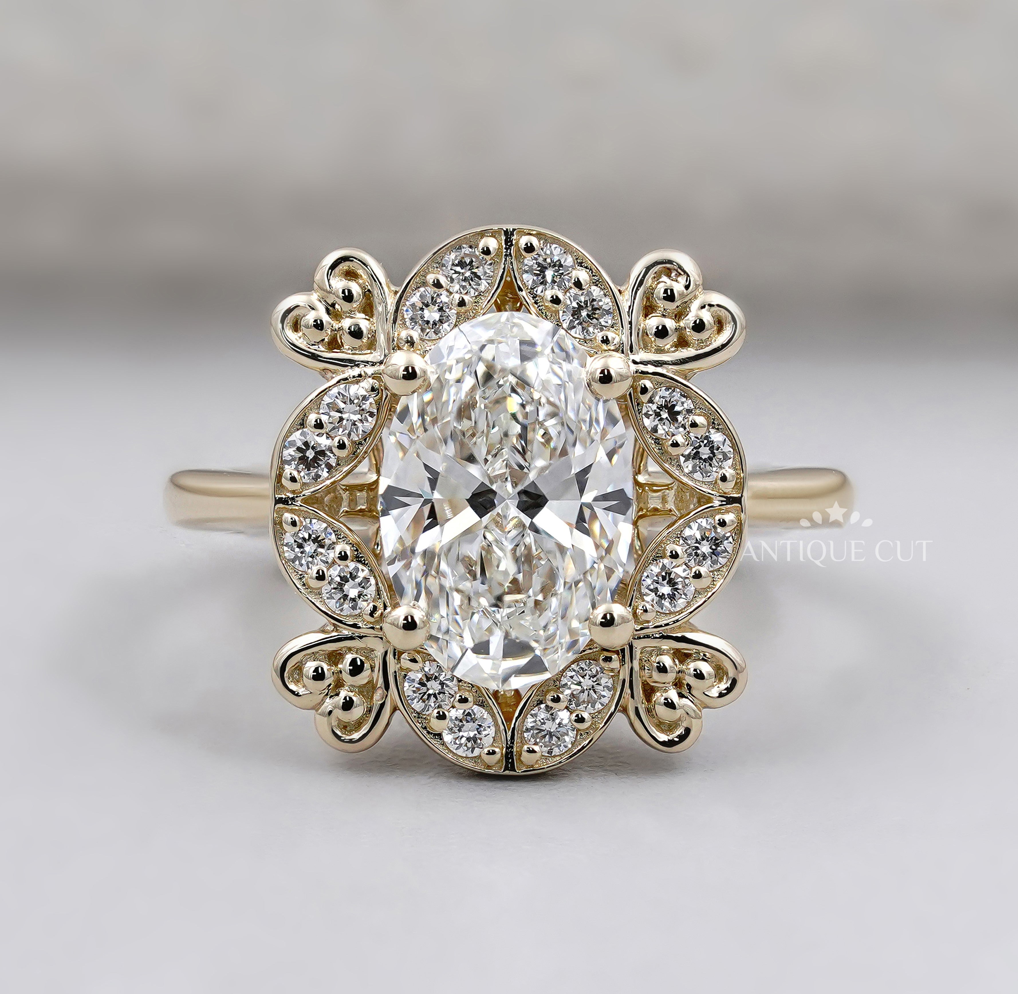 Oval diamond engagement ring with floral halo and round diamond accents in yellow gold