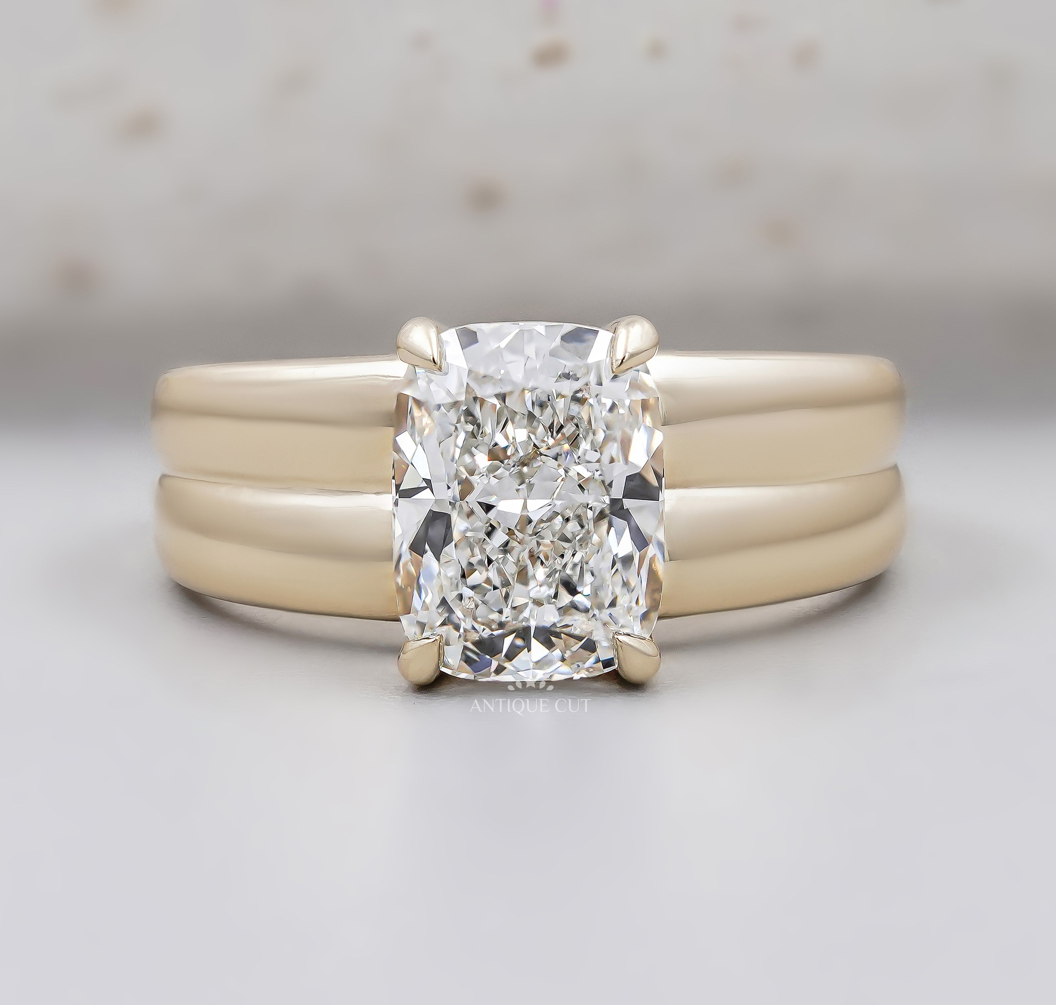 Radiant cut diamond engagement ring with wide yellow gold band and four prong setting