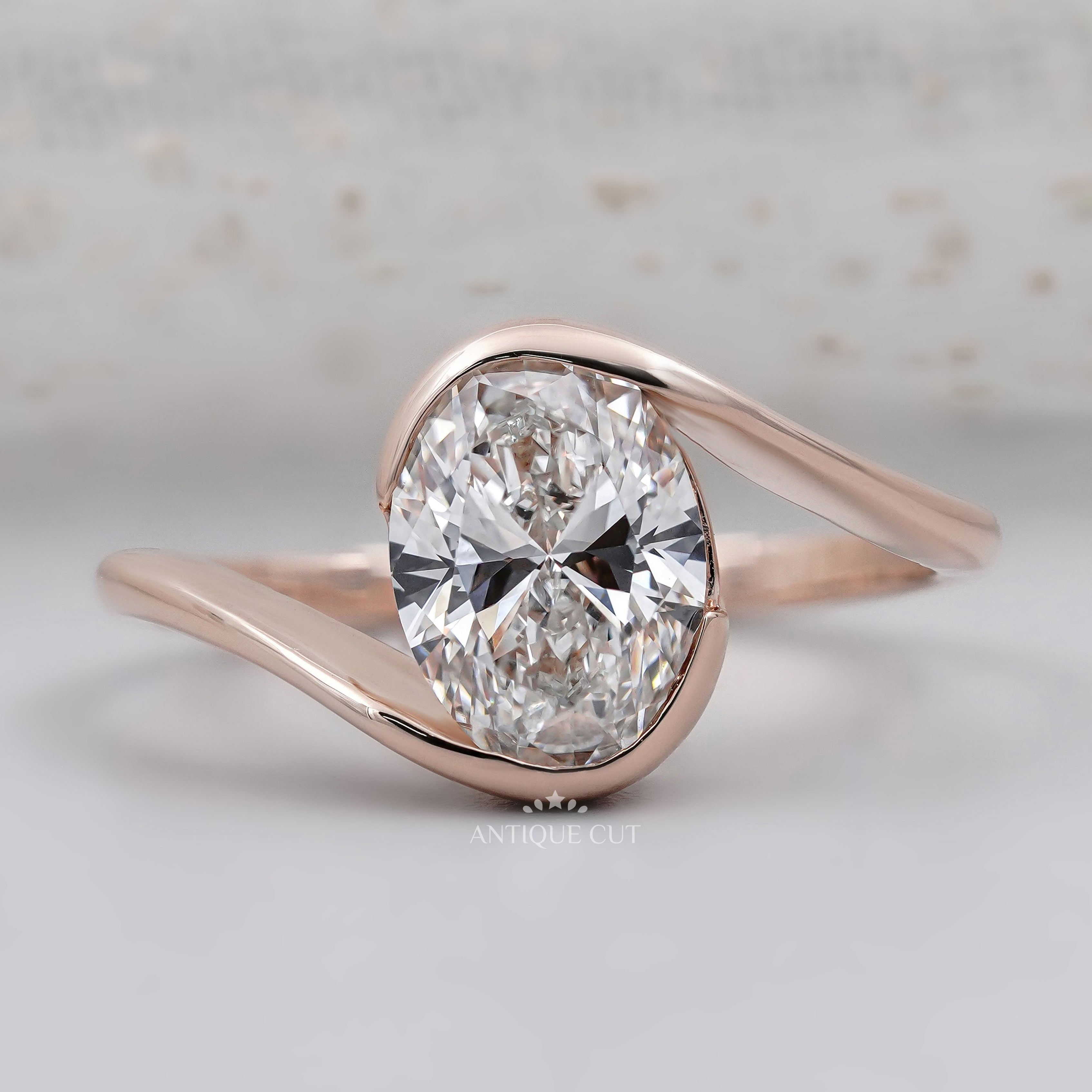Oval diamond engagement ring with bypass setting in rose gold