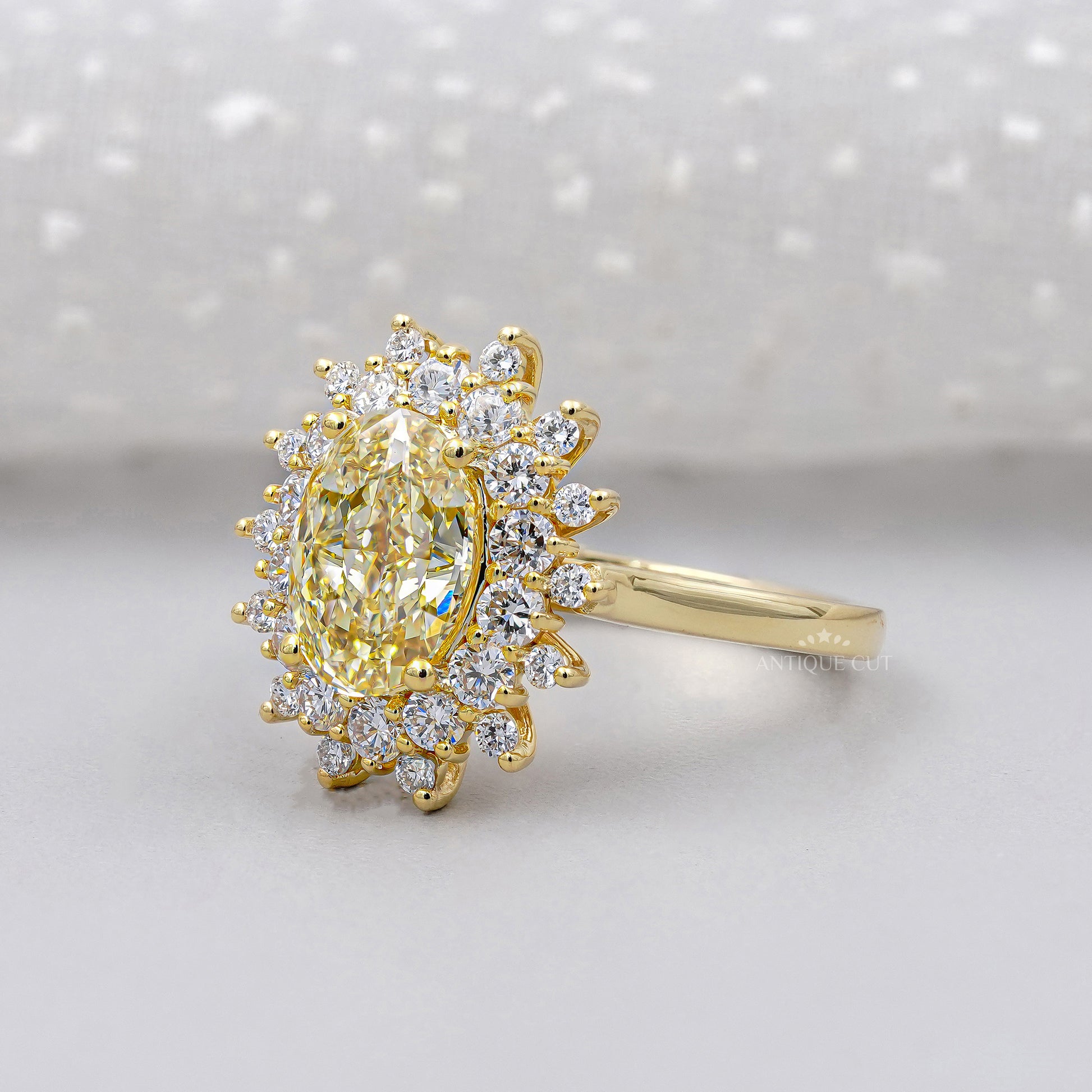 Gold ring with a yellow diamond and smaller diamonds on a white background

