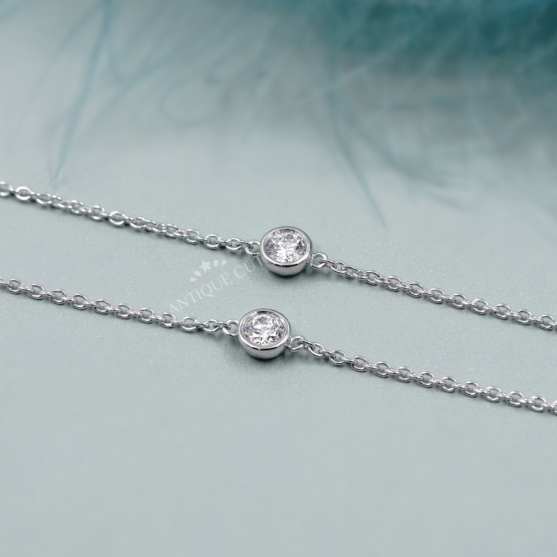 Silver necklace with small diamonds on a person wearing a green top