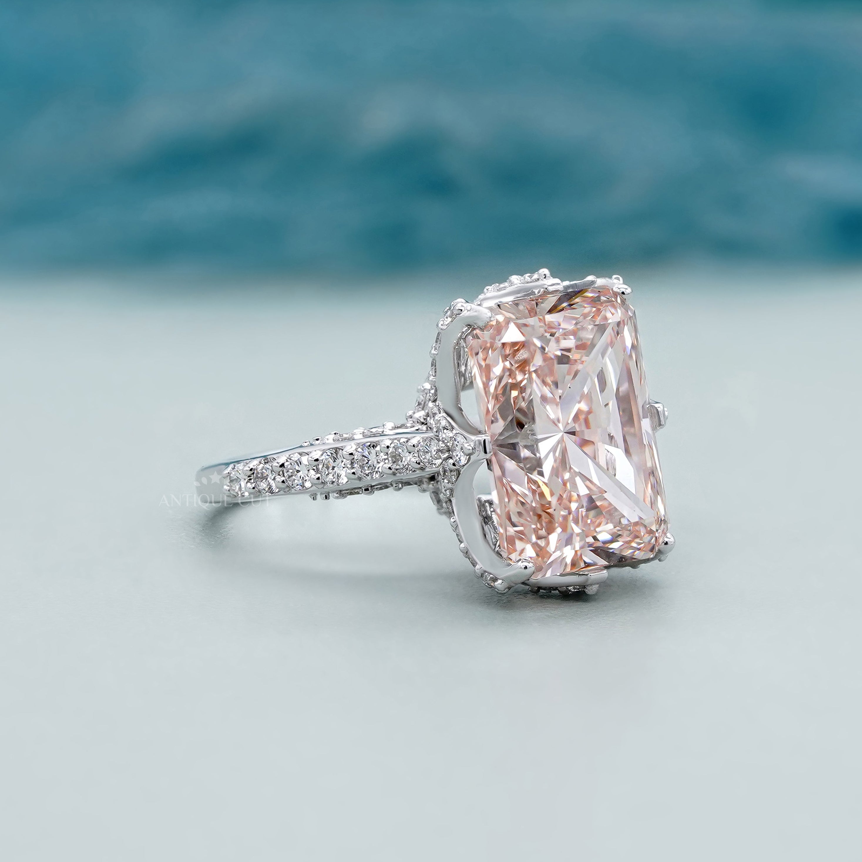 Radiant pink diamond ring with side stones and pave band