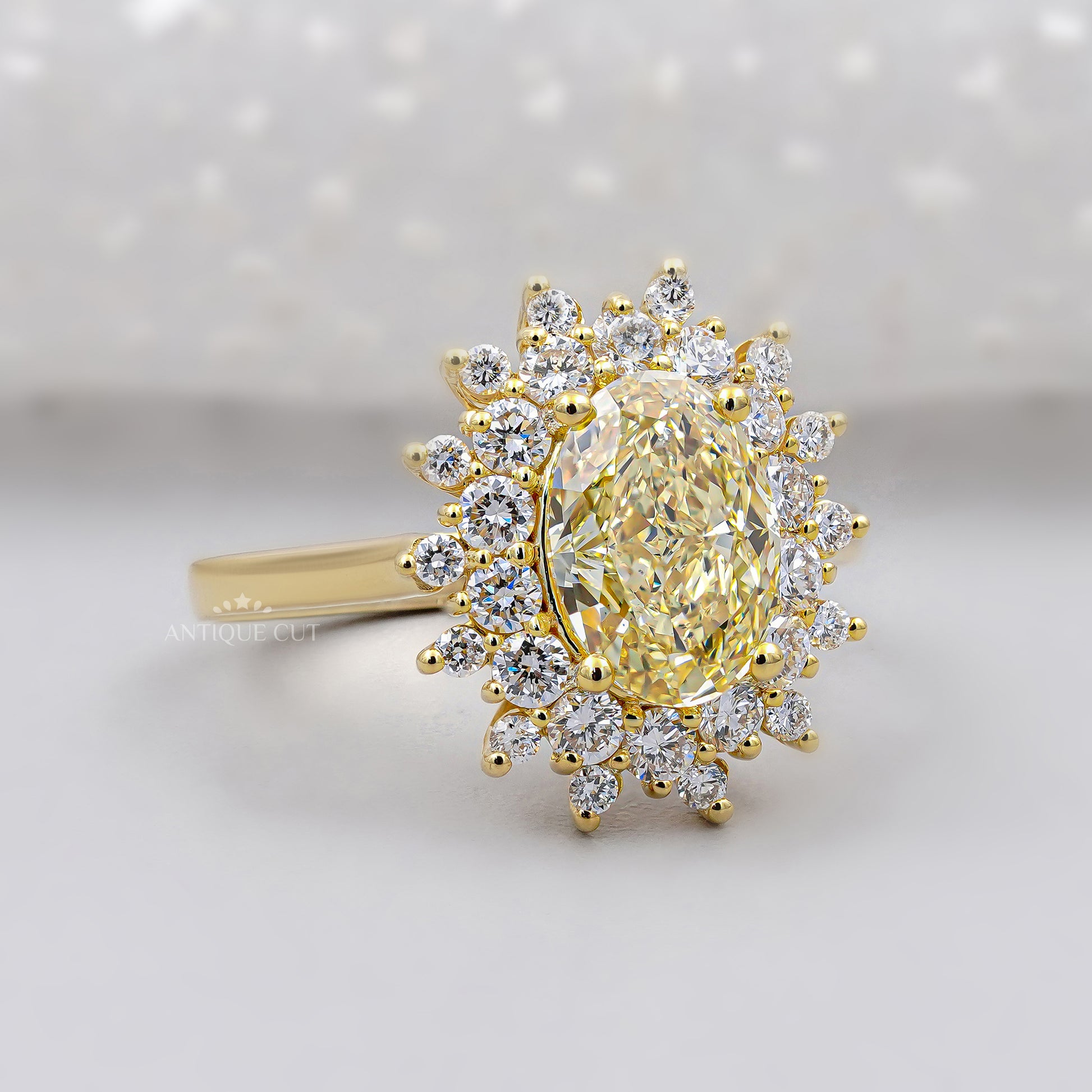 Gold ring with a yellow diamond and smaller diamonds on a white background

