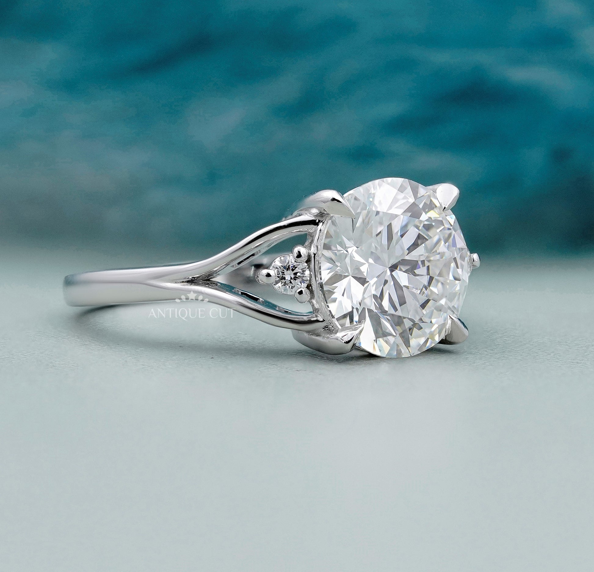 Round diamond engagement ring with leaf inspired side setting
