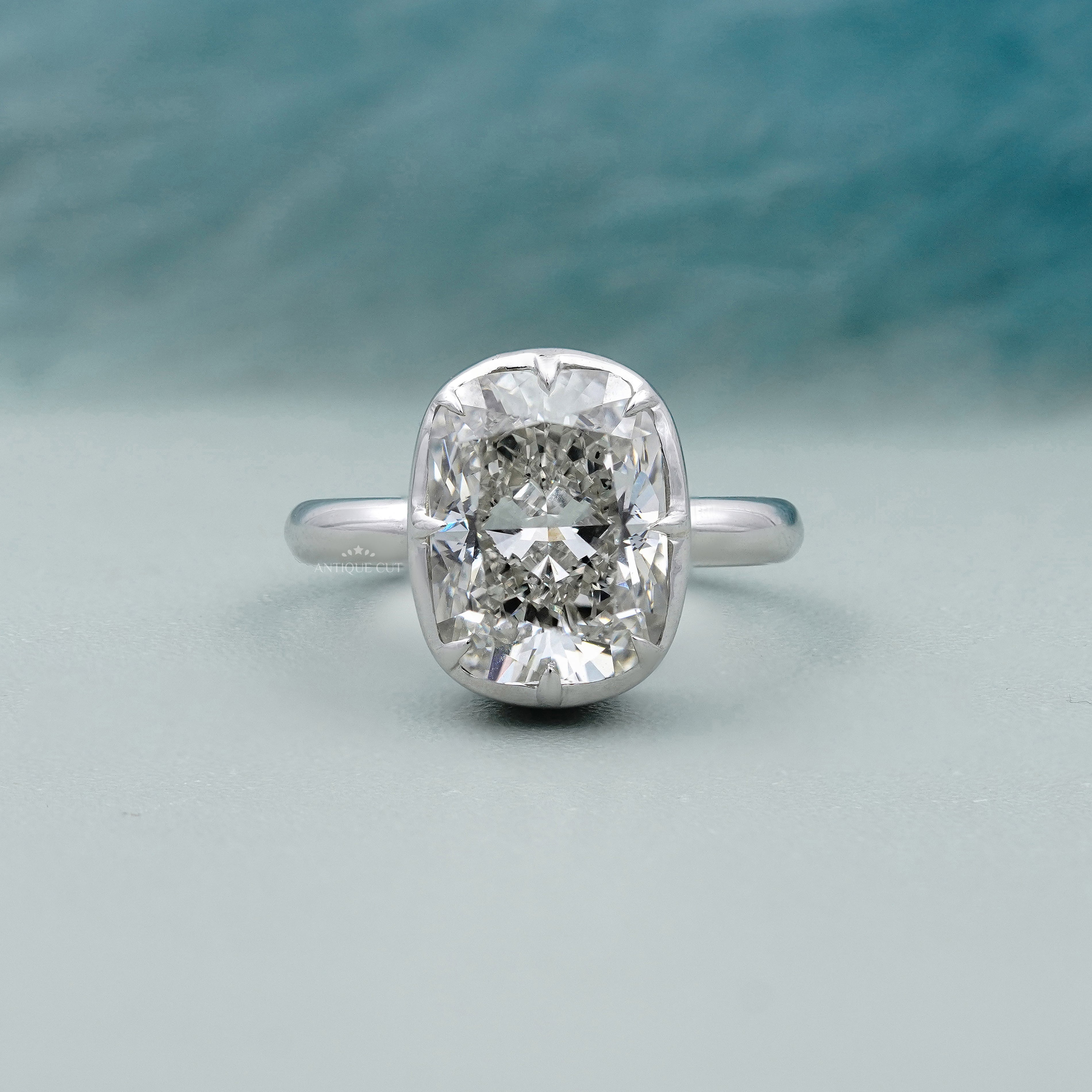 Cushion solitaire engagement ring with bezel setting