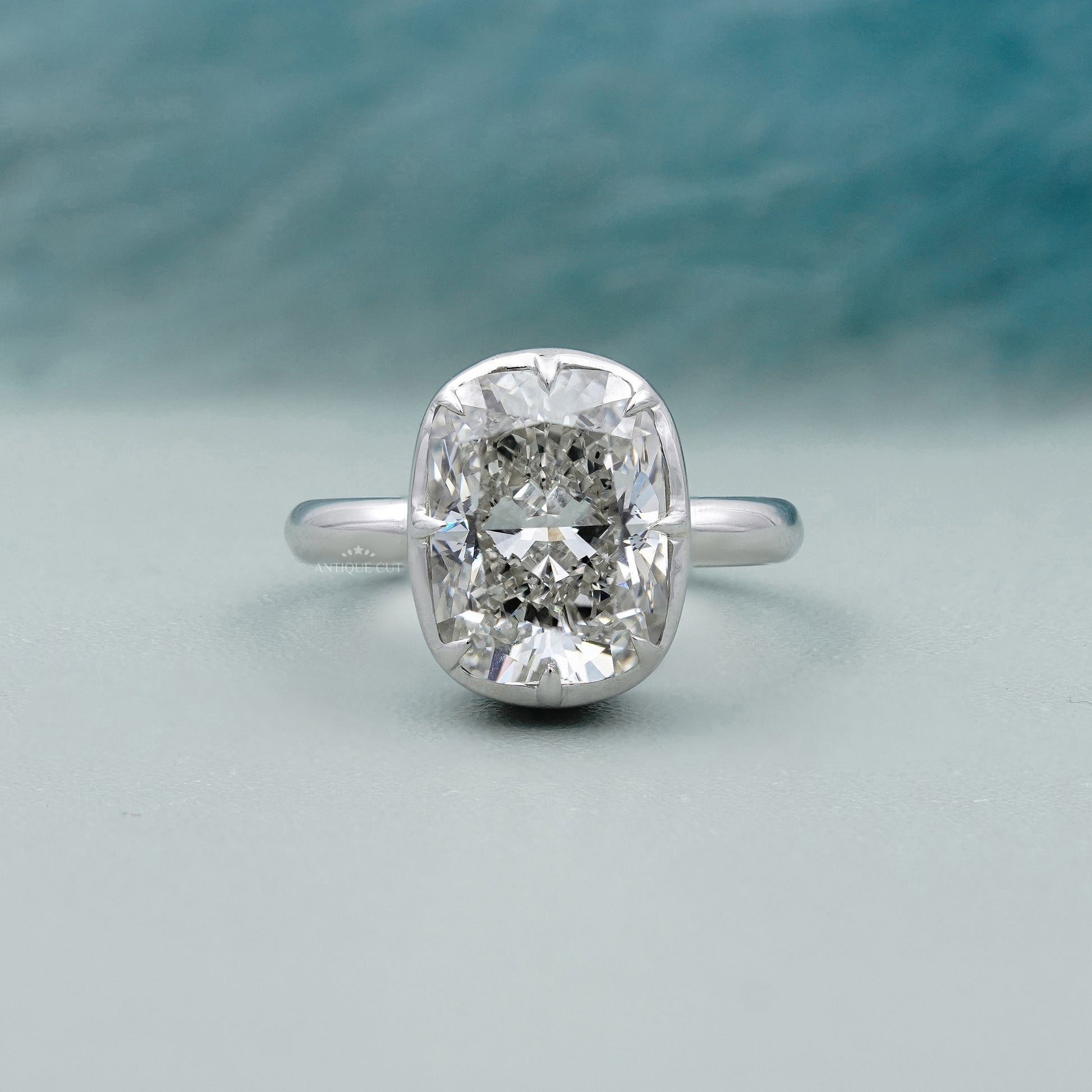 Cushion solitaire engagement ring with bezel setting