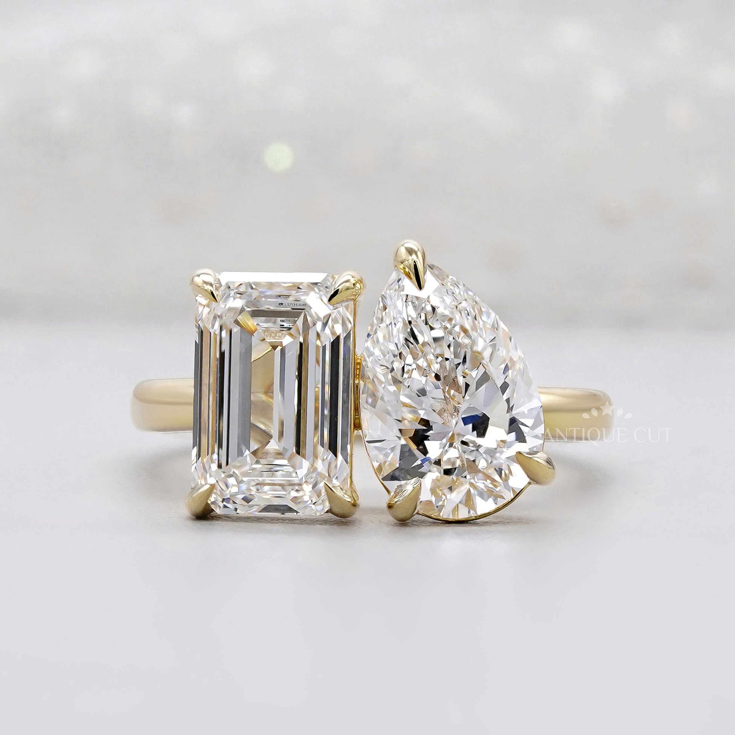 Emerald and pear cut engagement ring in yellow gold