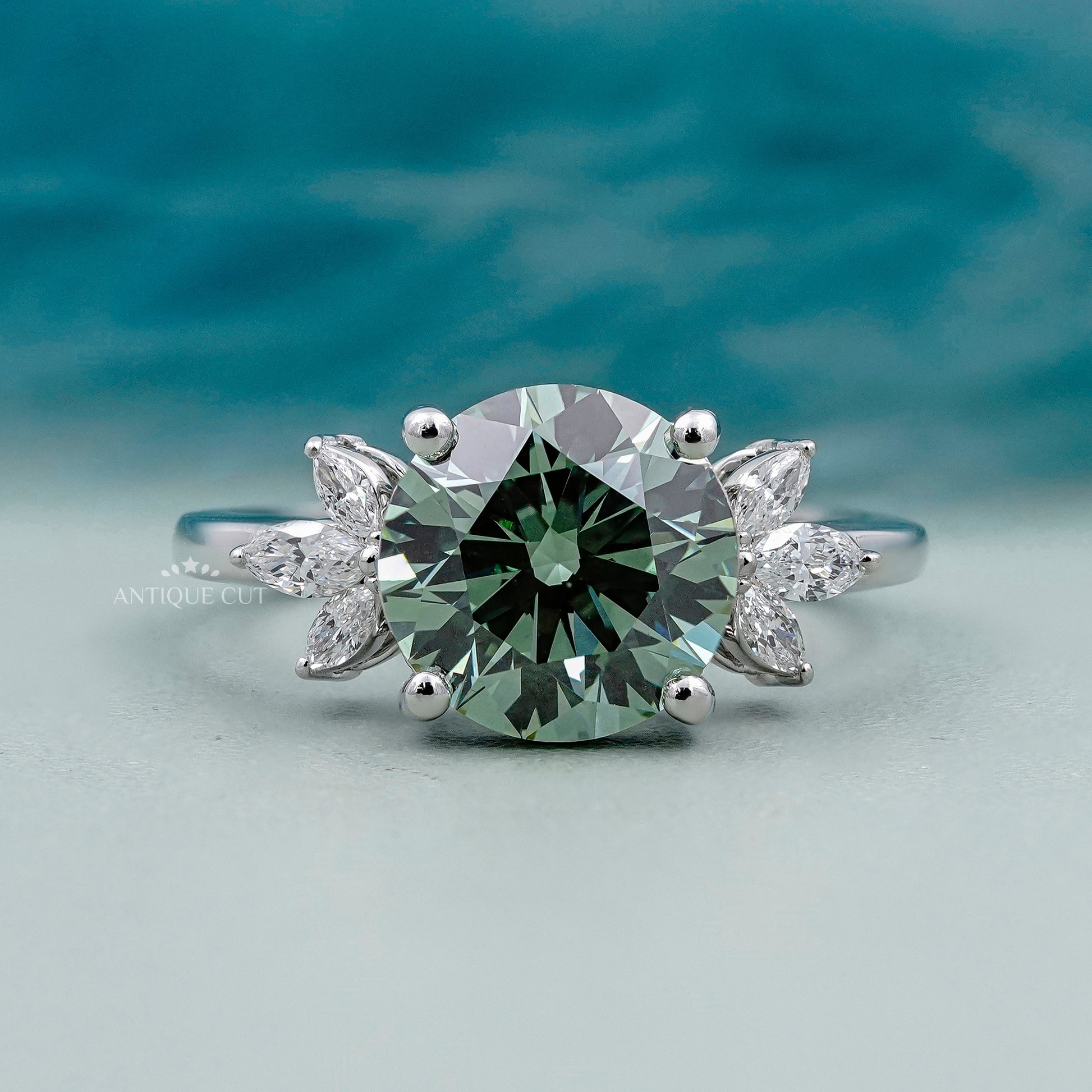Round cut antique green diamond ring with marquise side stones