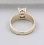 Radiant diamond solitaire ring with wide yellow gold shank and four prongs