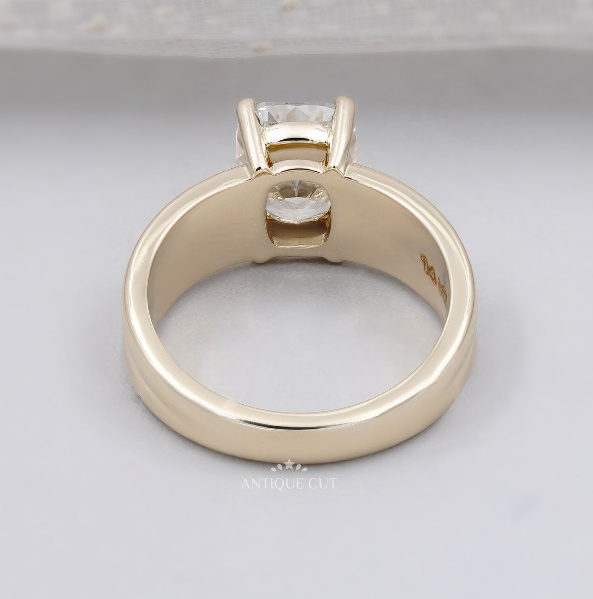 Radiant diamond solitaire ring with wide yellow gold shank and four prongs