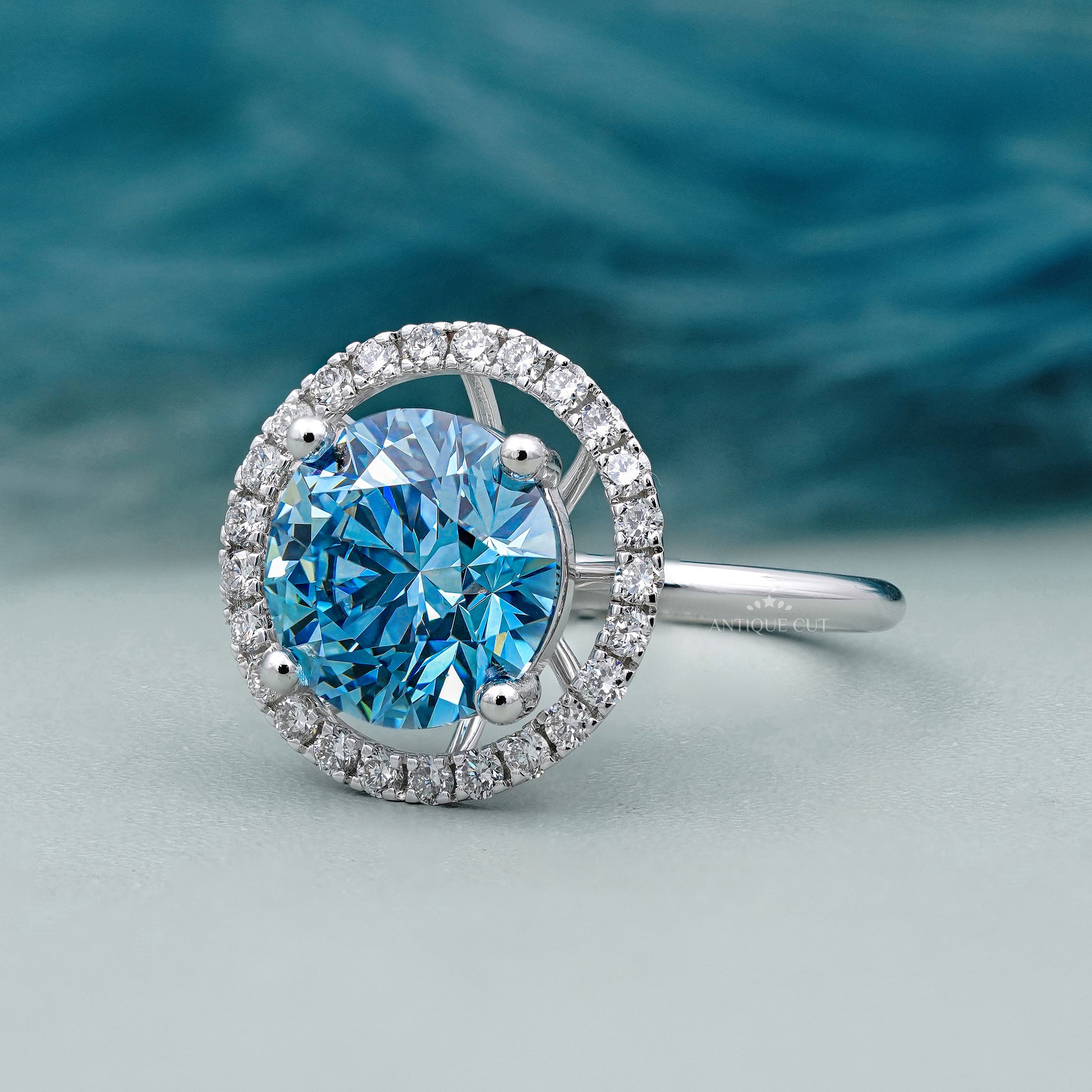 Silver ring with a blue gemstone on a light gray background

