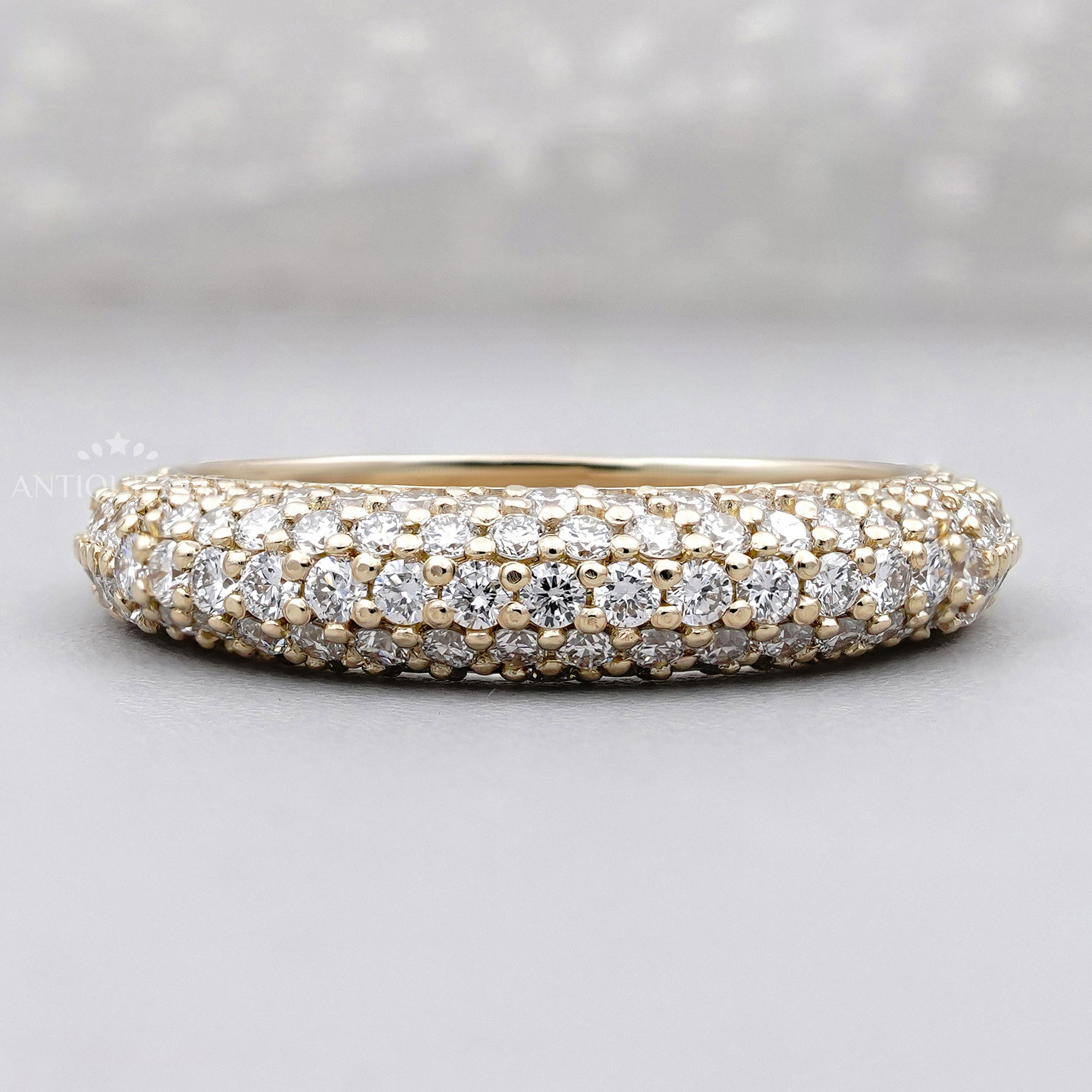 Pave diamond wedding band in yellow gold with multiple rows of round brilliant diamonds.