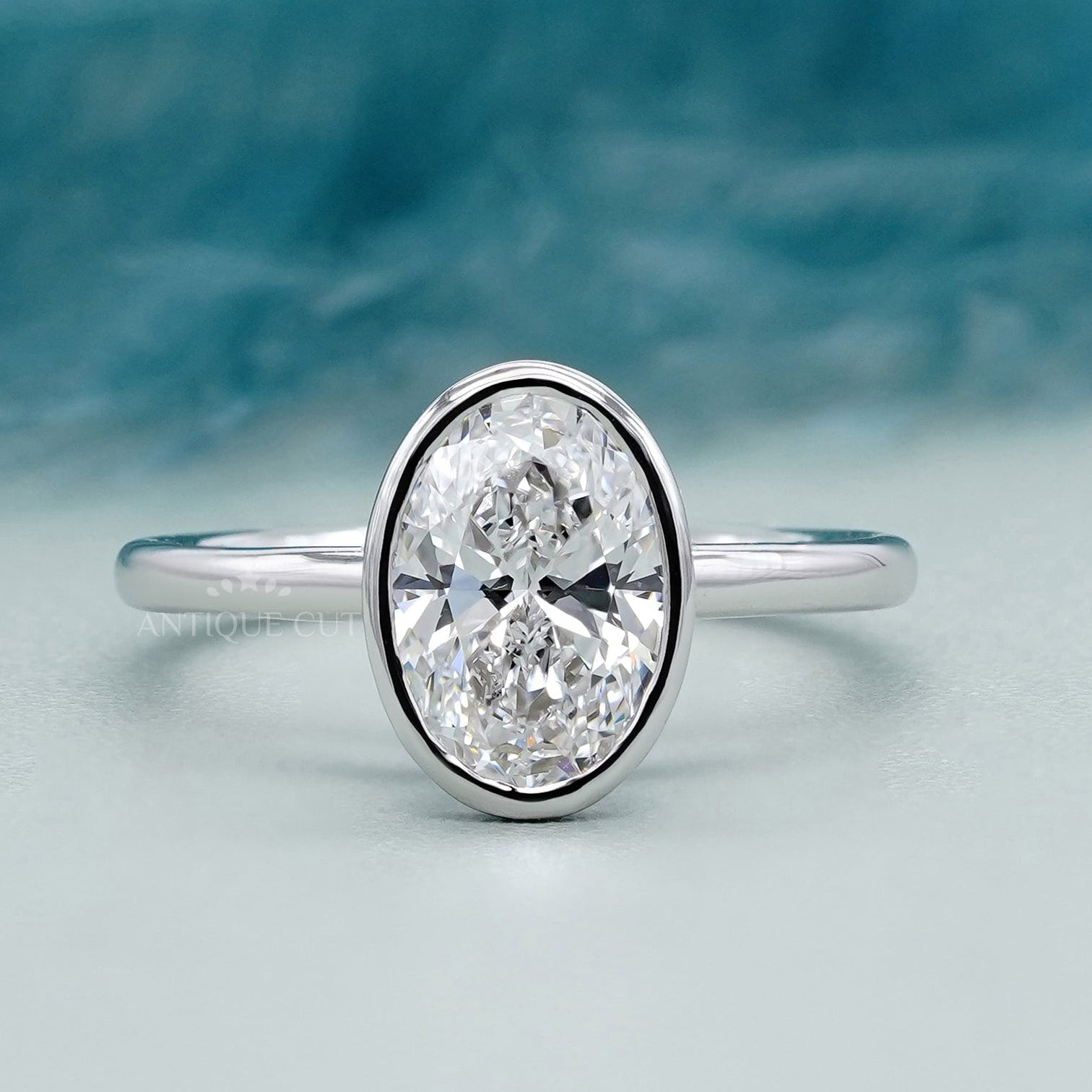 Bezel set oval diamond engagement ring in white gold