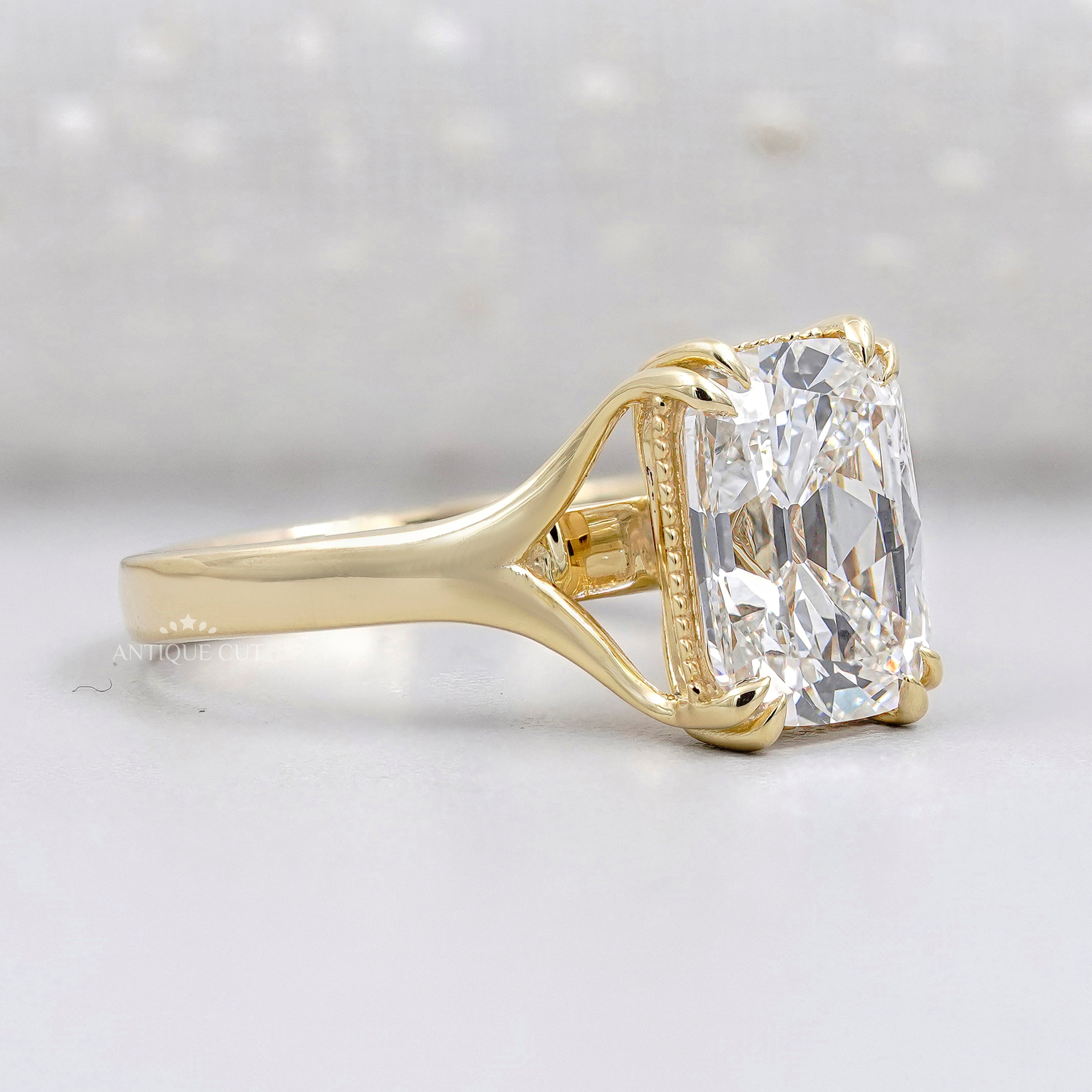 Elongated radiant diamond solitaire ring with yellow gold band