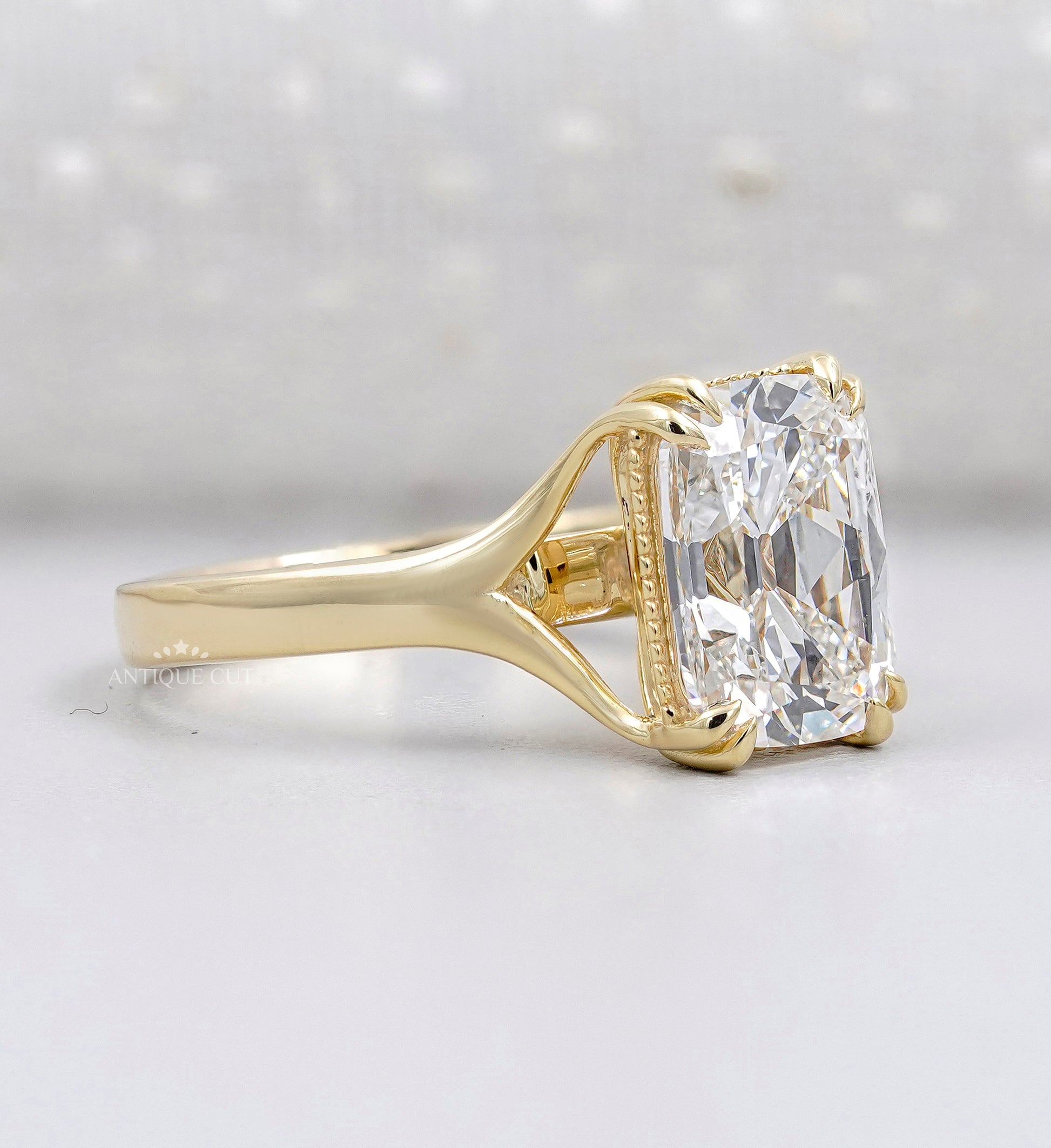 Elongated radiant diamond solitaire ring with yellow gold band
