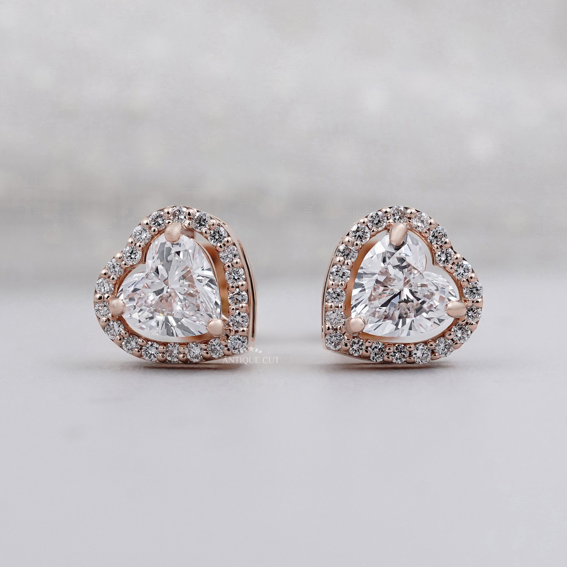 Heart cut diamond stud earrings with halo setting in rose gold