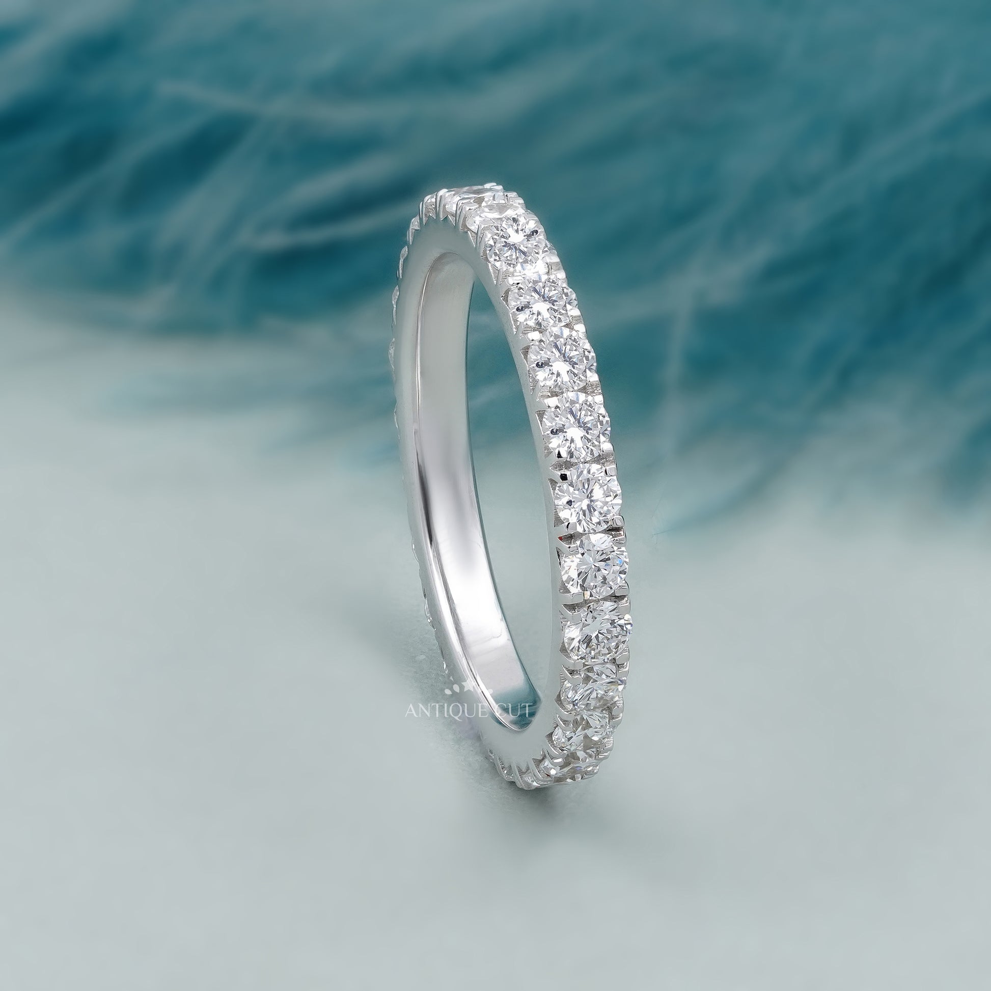 Silver ring with diamonds on a soft blue background

