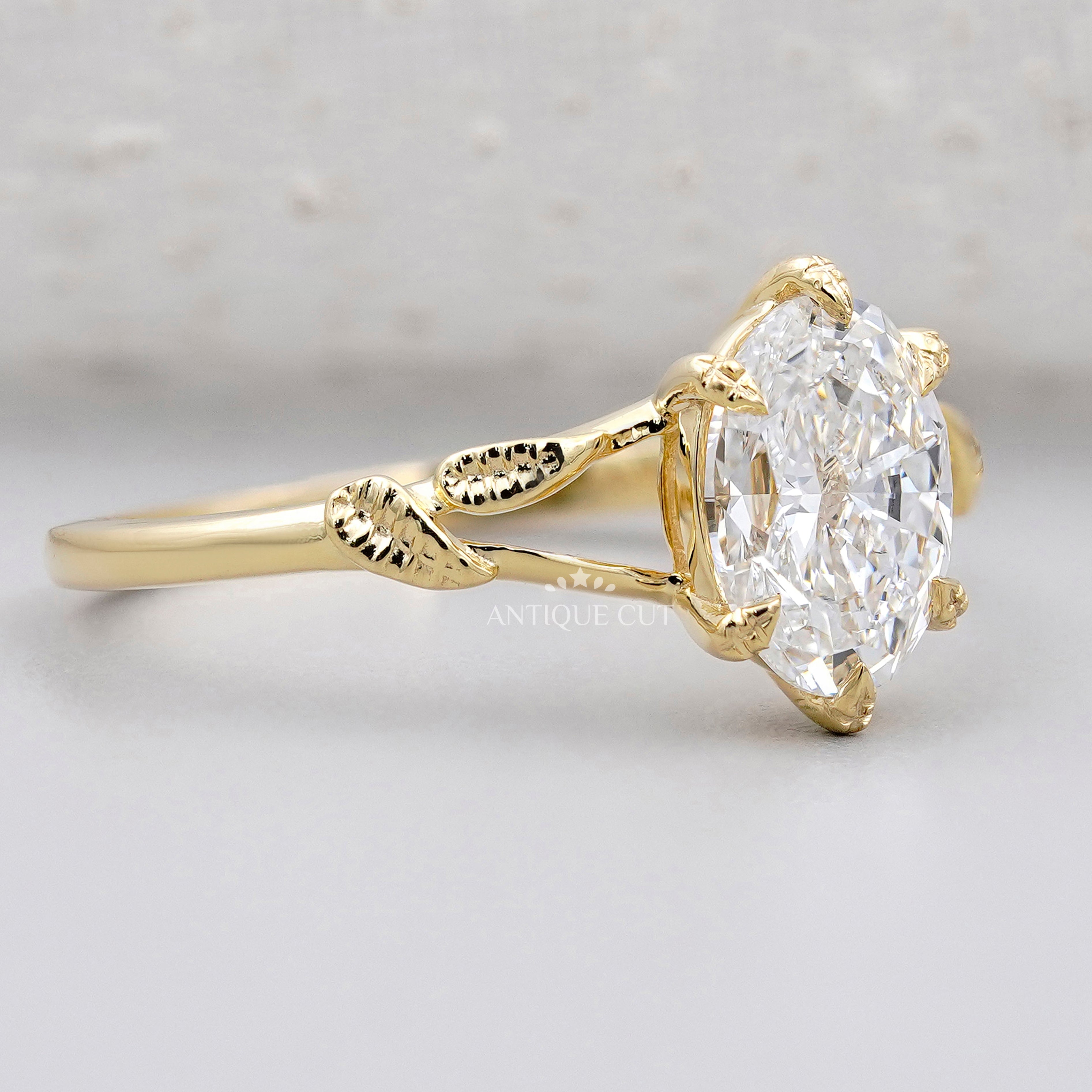 Oval diamond solitaire with floral leaf band