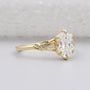 Oval diamond solitaire with floral leaf band