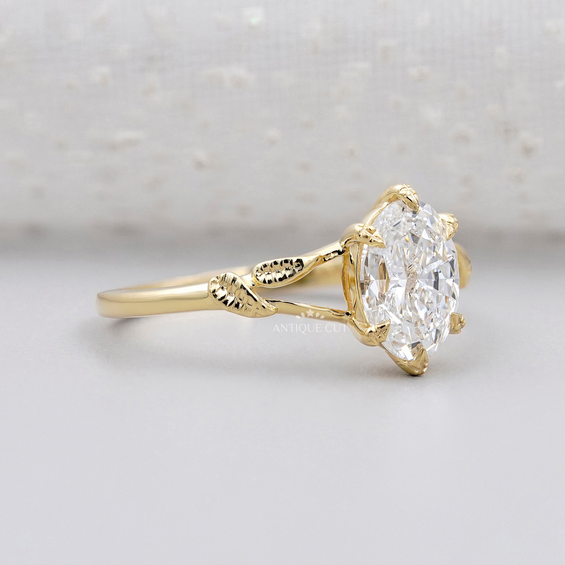 Oval diamond solitaire with floral leaf band