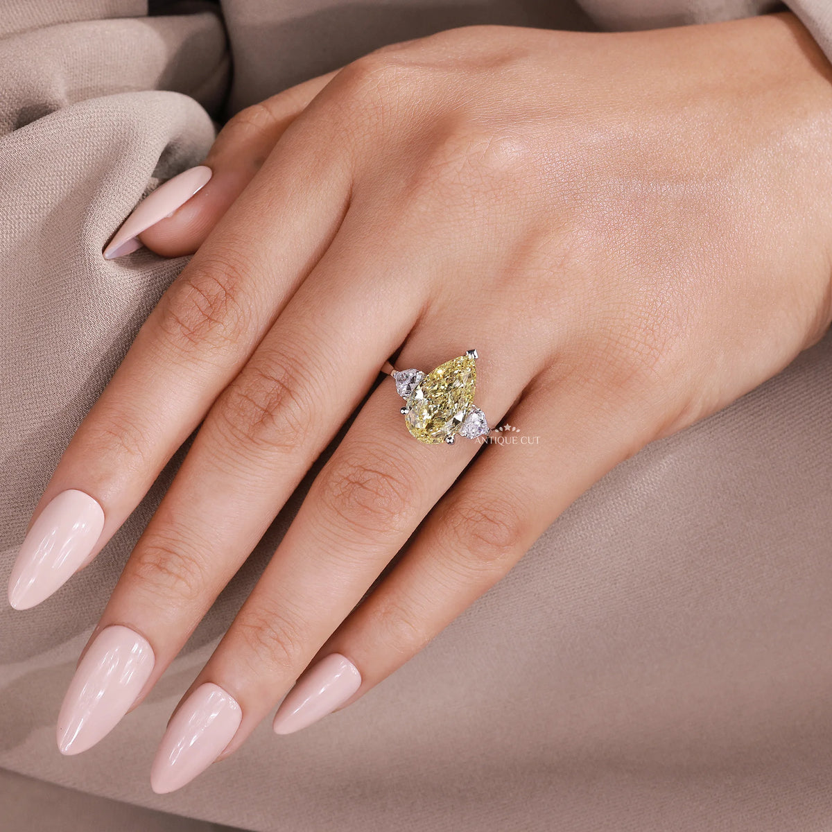 Pear shaped yellow diamond engagement ring with side stones