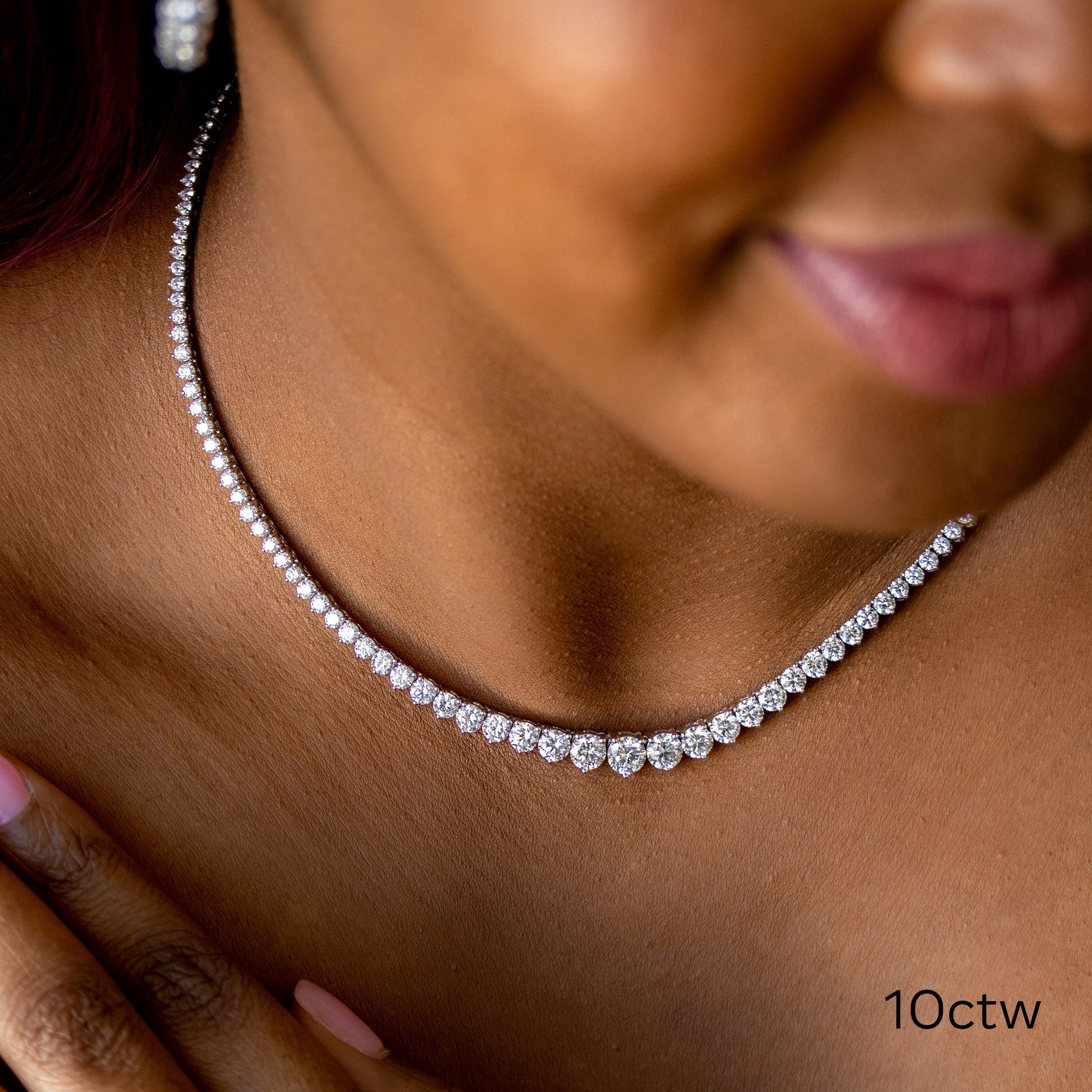 Diamond tennis necklace on a woman's neck.