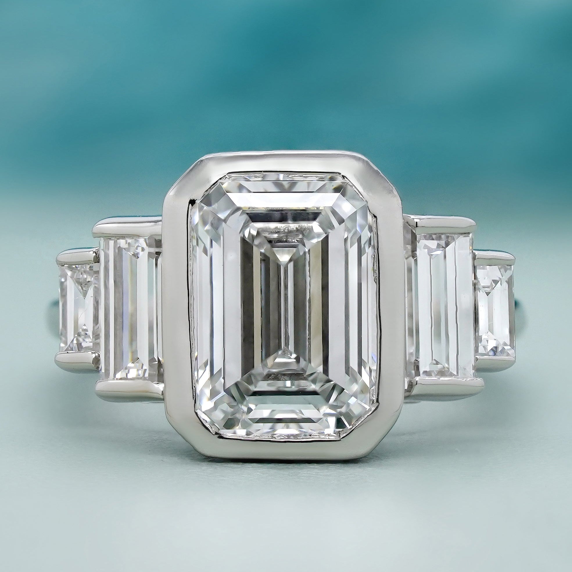 Emerald cut bezel set engagement ring in white gold