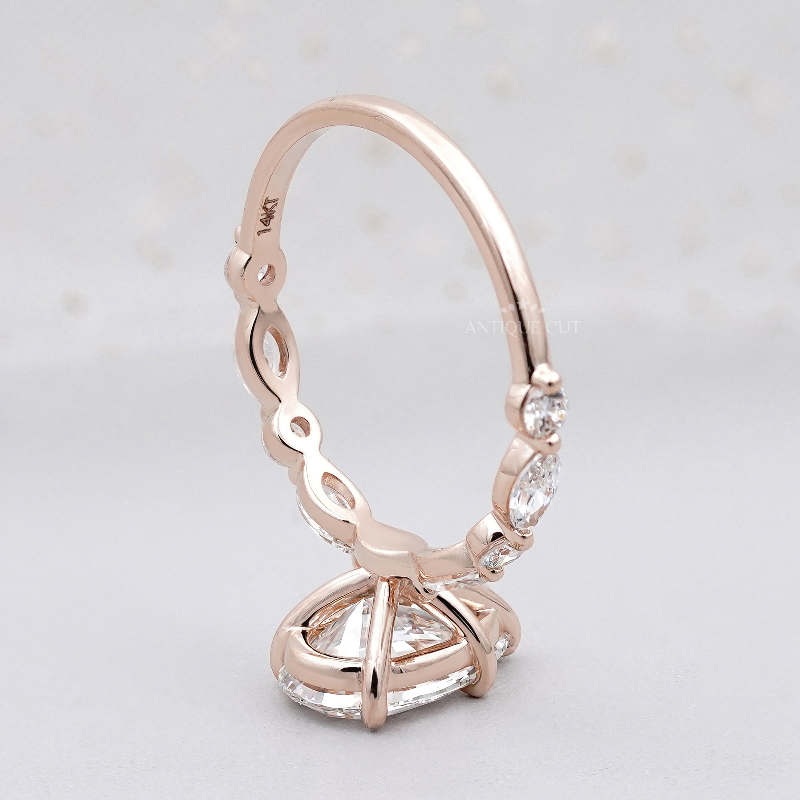 Rose gold pear diamond engagement ring with side stones