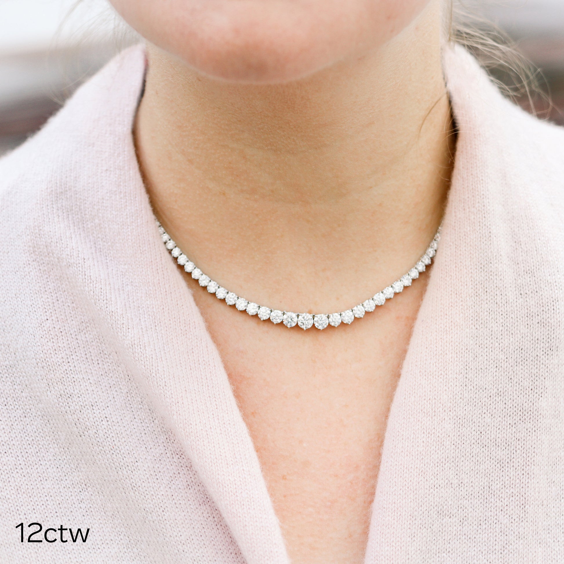 Woman wearing diamond tennis necklace.