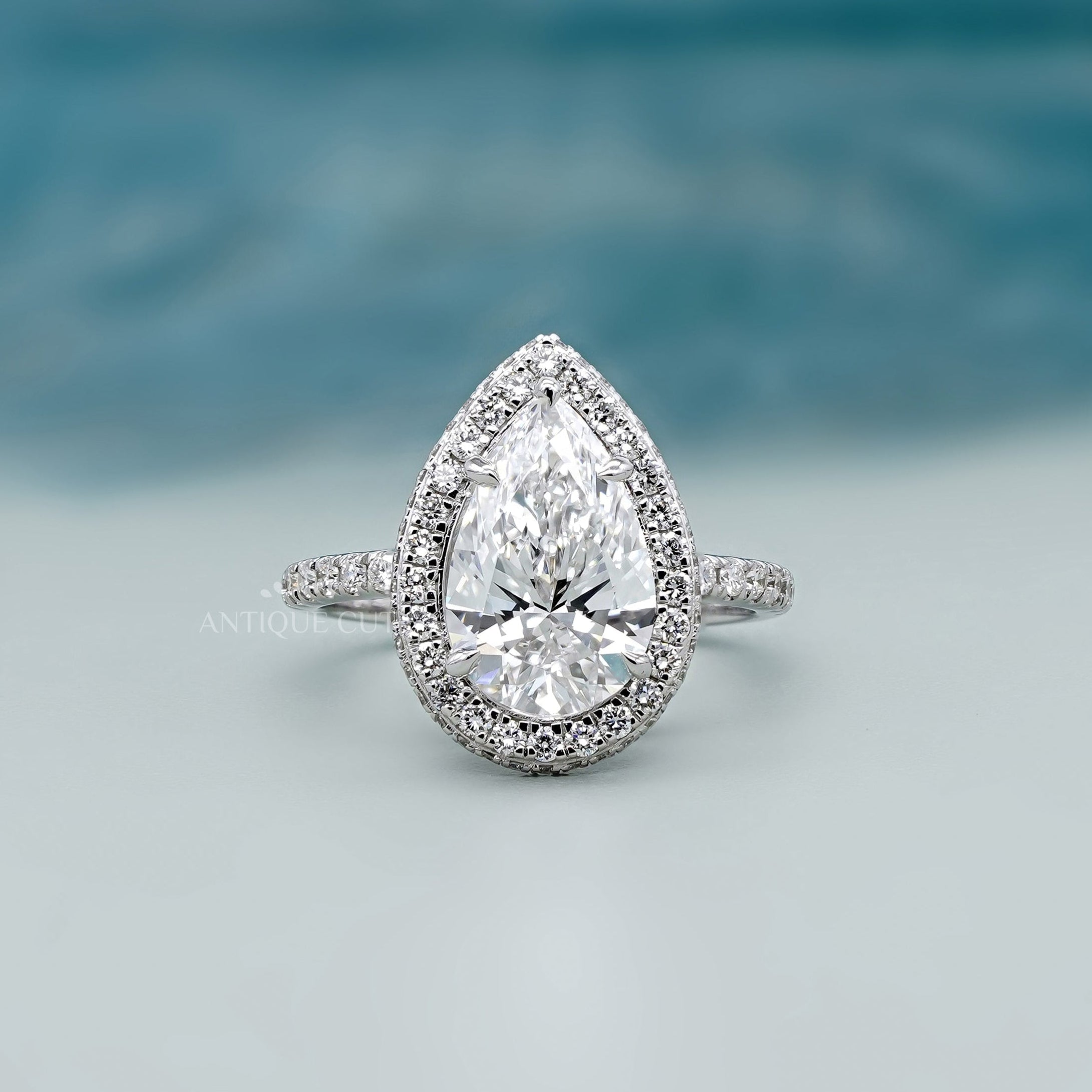 Pear halo engagement ring with pave band in white gold