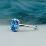 Silver ring with a blue gemstone on a light gray background