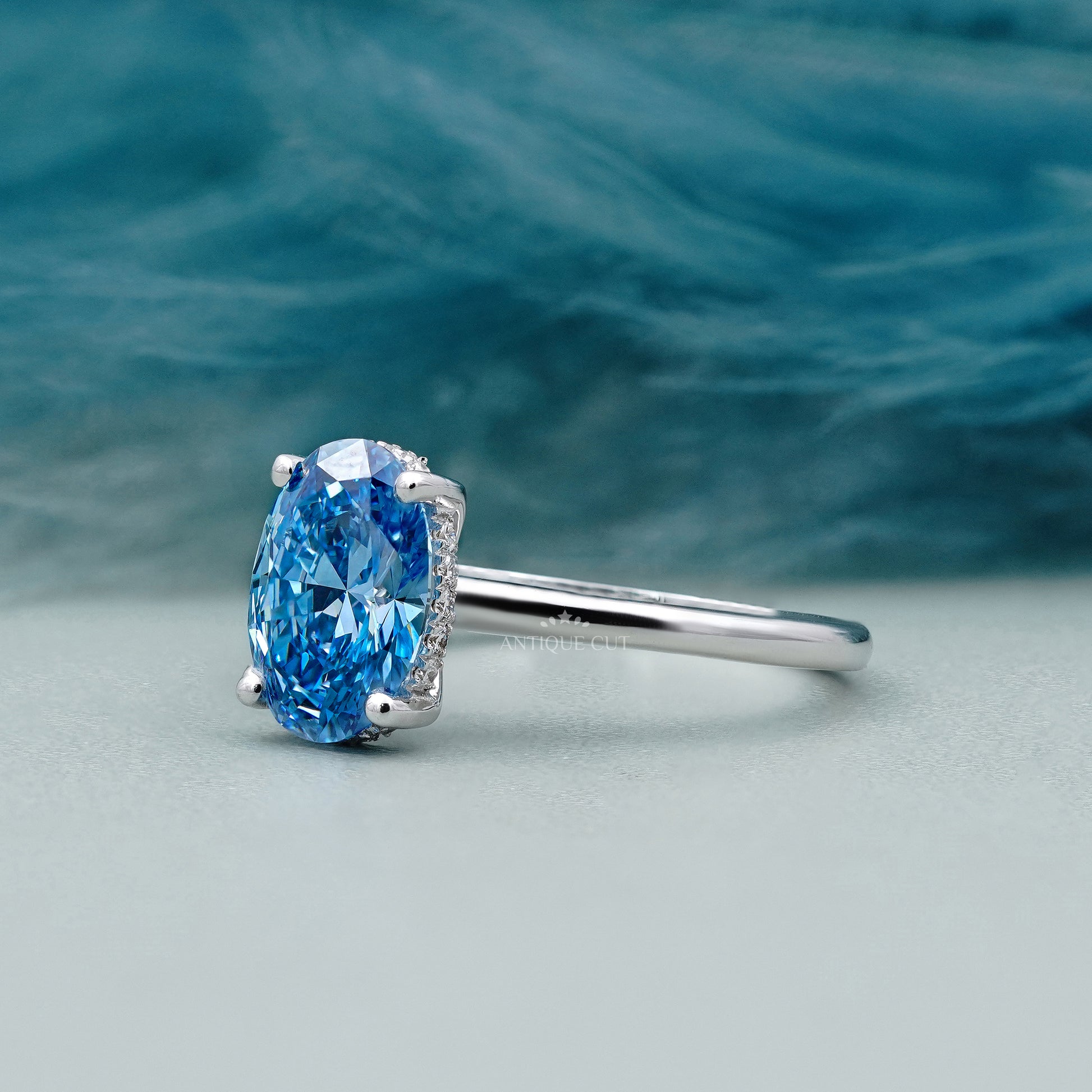 Silver ring with a blue gemstone on a light gray background
