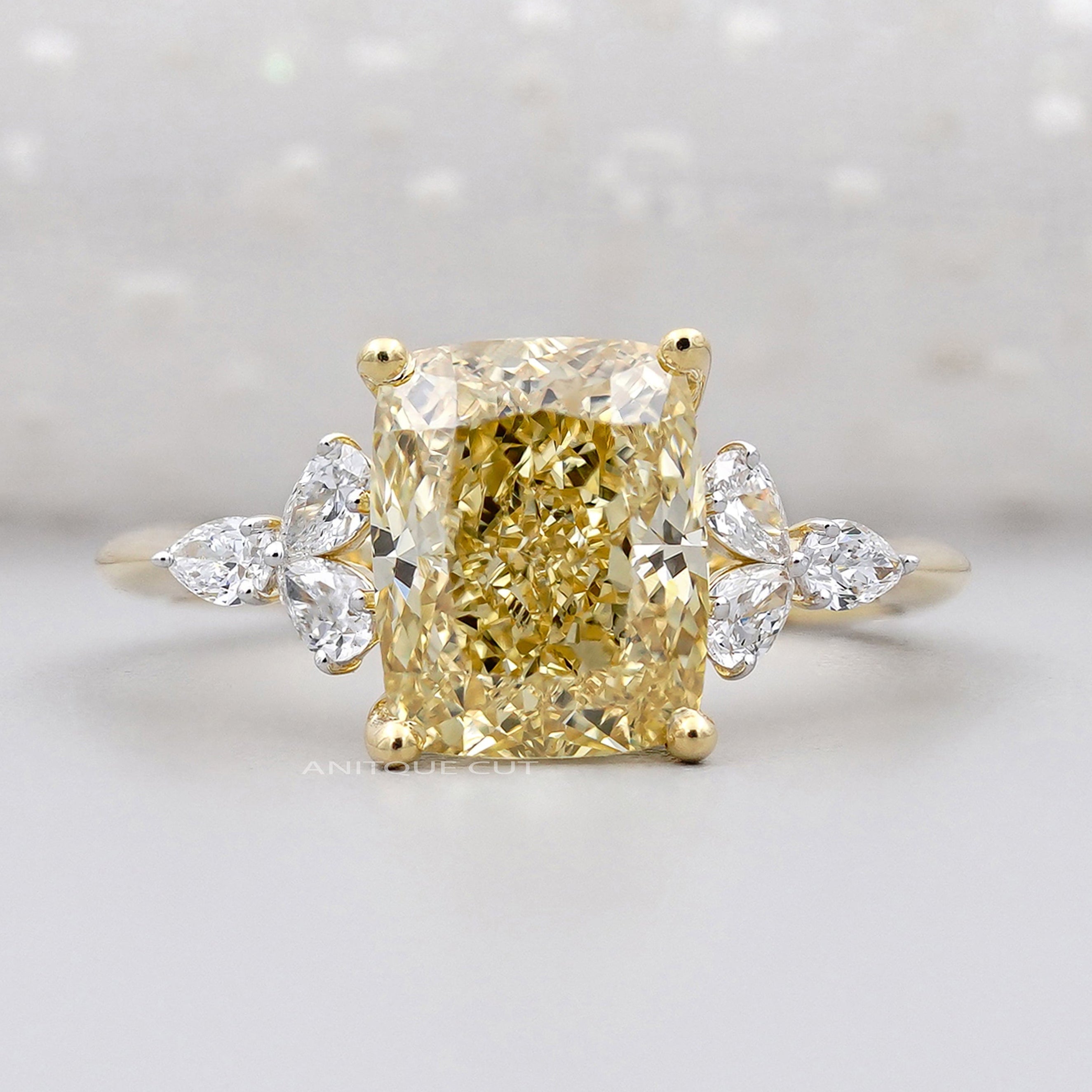 Yellow cushion cut diamond side stone engagement ring yellow gold