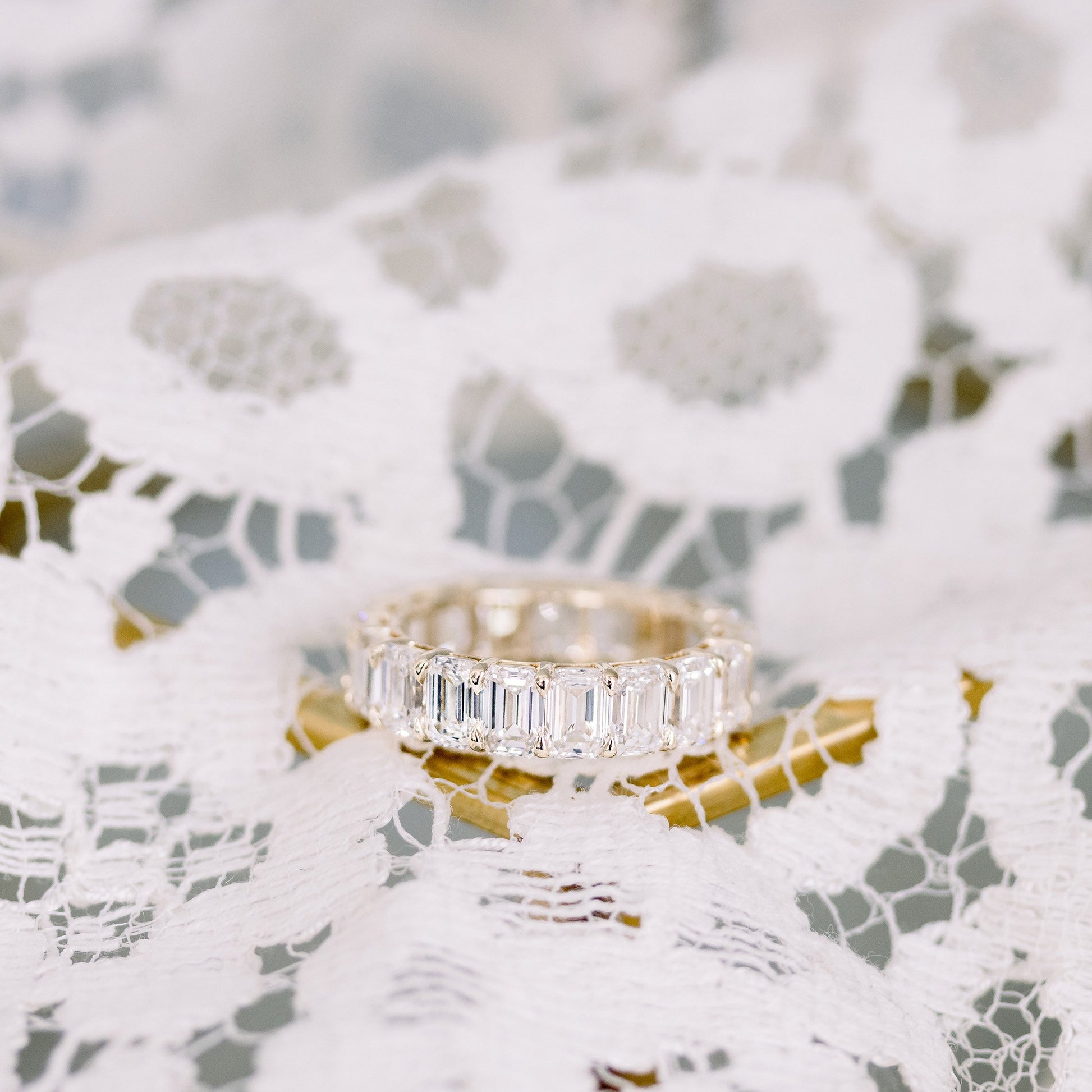Emerald cut diamond eternity ring on lace.
