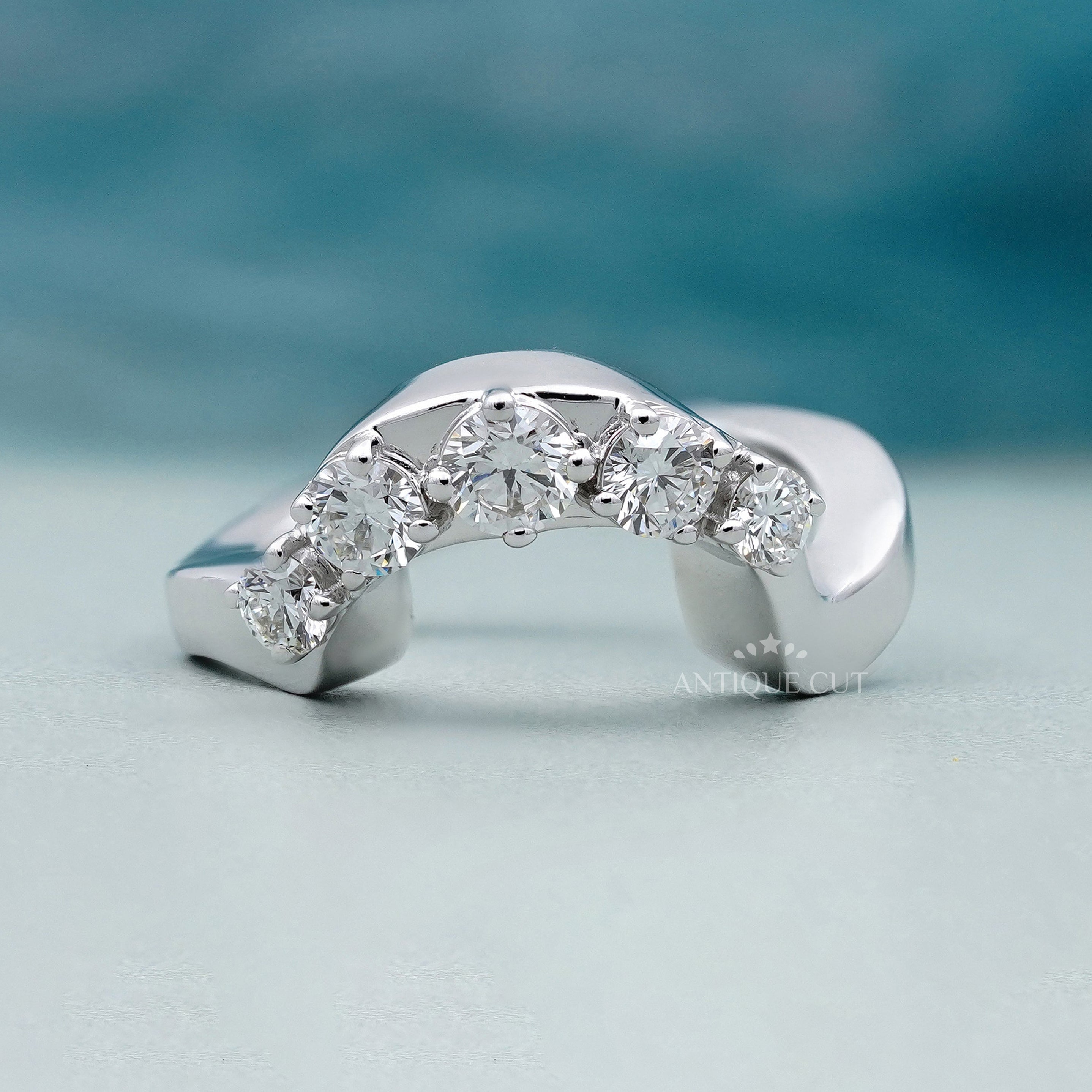 Curved five stone round diamond ring in polished white gold