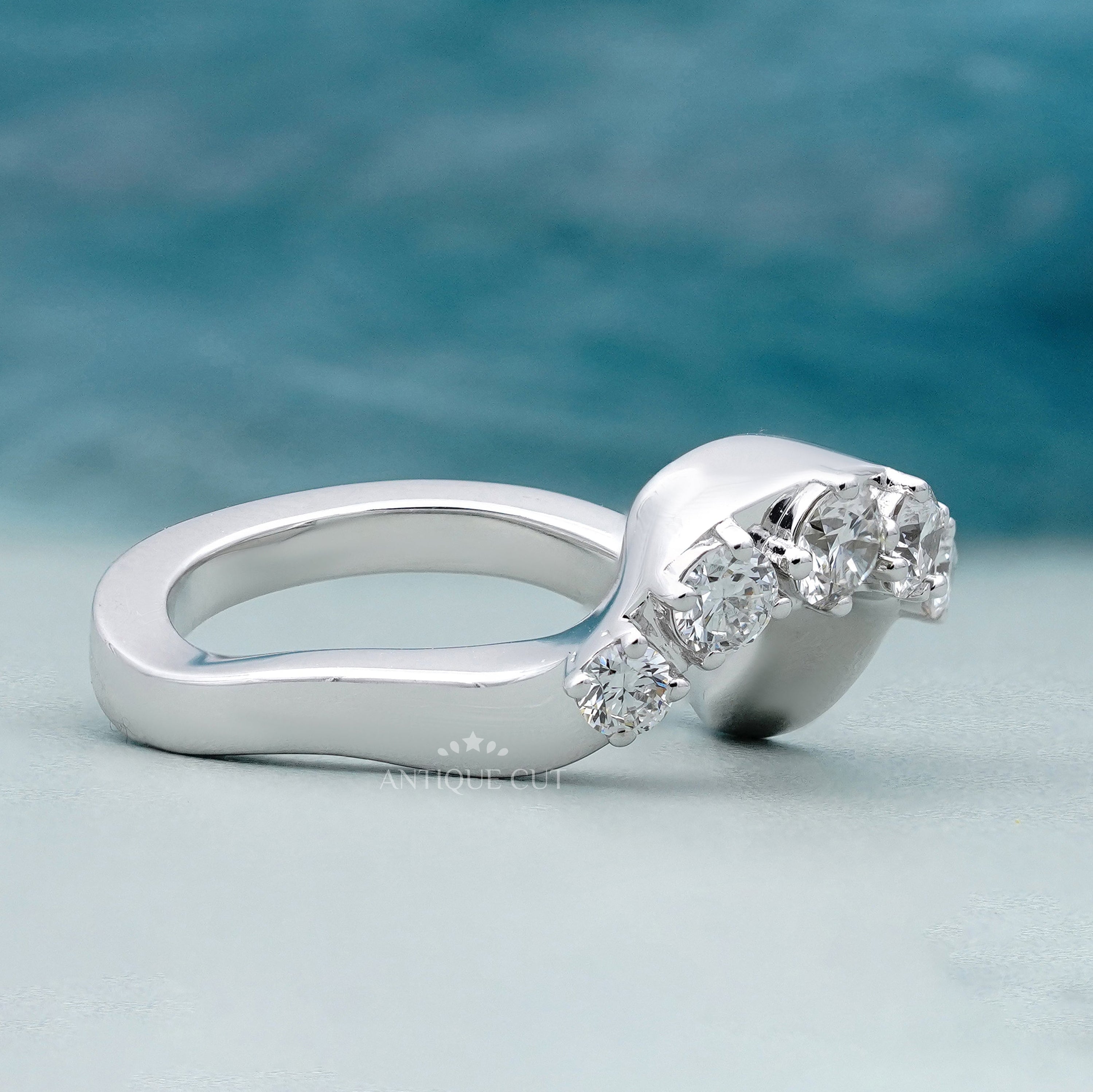Round diamond wedding band with an arched open shank design
