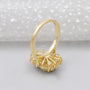 Gold ring with a yellow diamond and smaller diamonds on a white background

