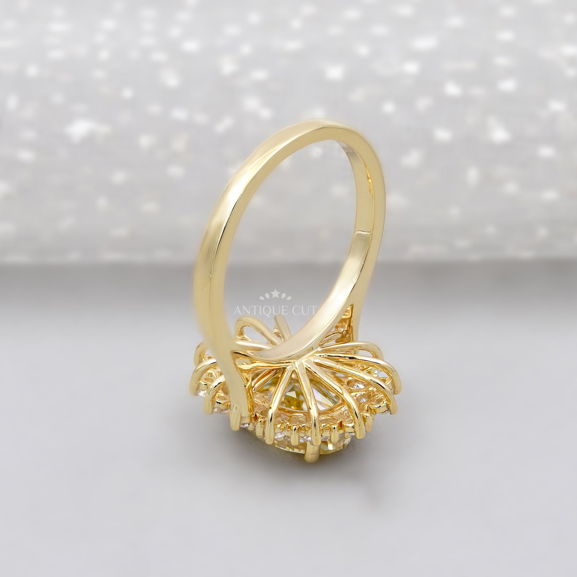 Gold ring with a yellow diamond and smaller diamonds on a white background

