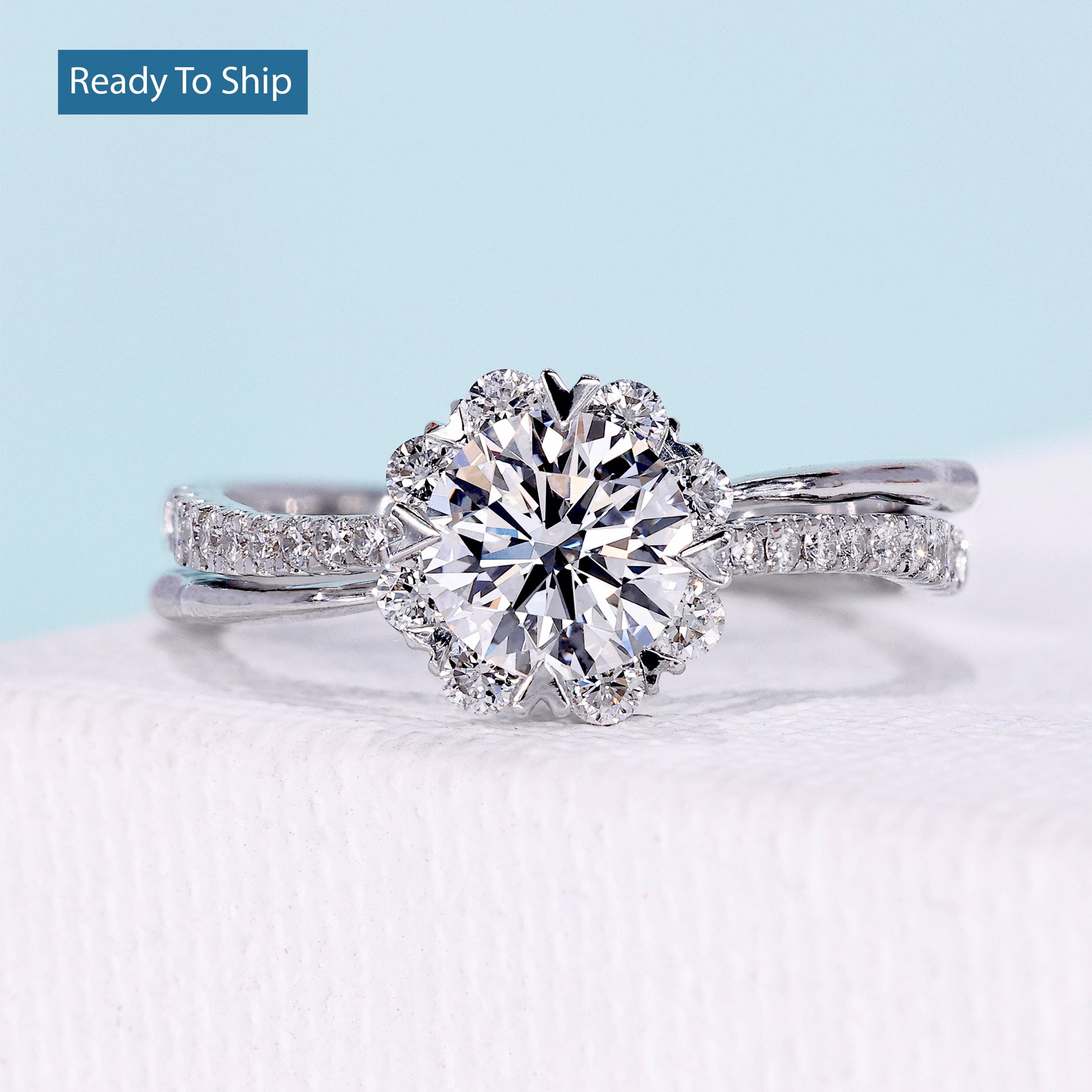 Floral halo engagement ring with round cut diamond and twisted pavé band
