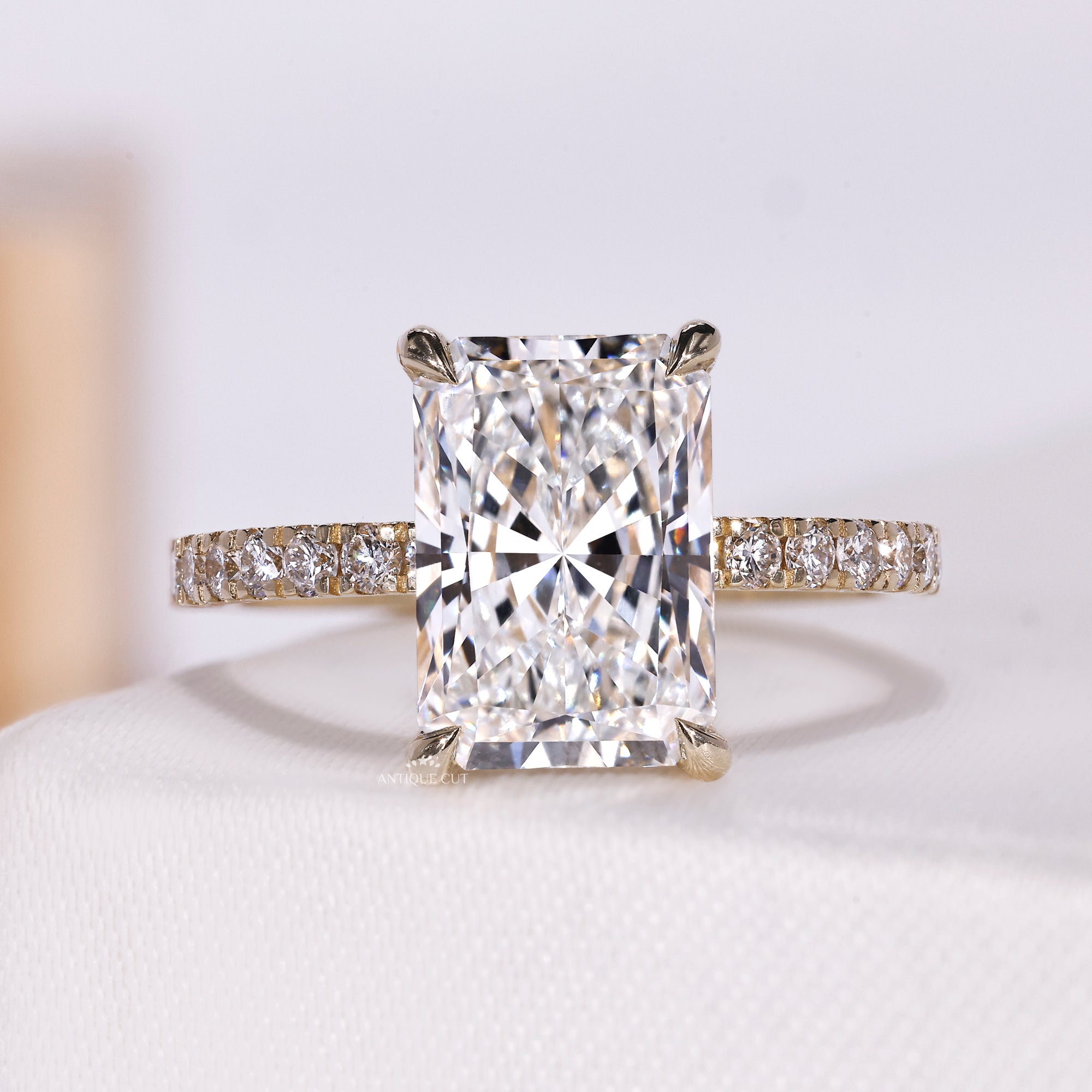 Radiant cut diamond ring with hidden halo and pave band