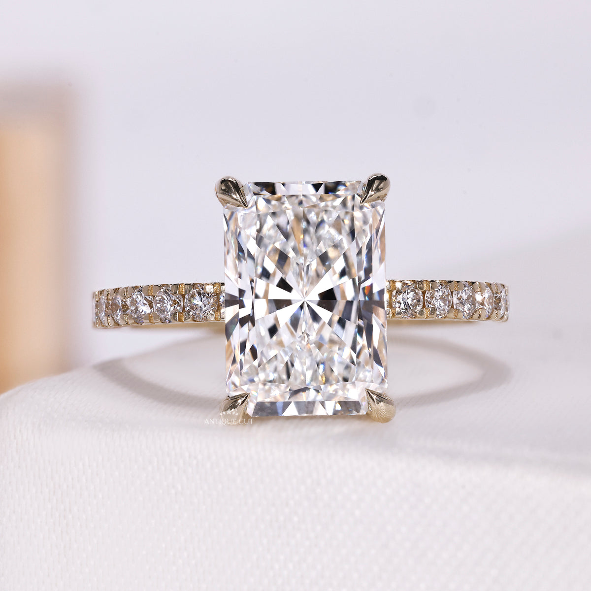 Radiant cut diamond ring with hidden halo and pave band