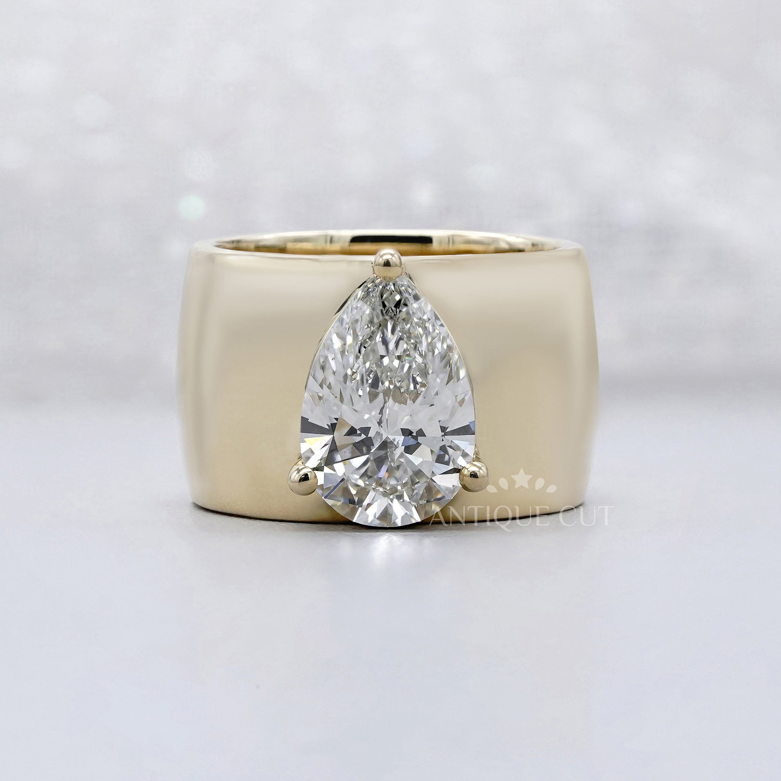Pear cut engagement ring with wide band in yellow gold