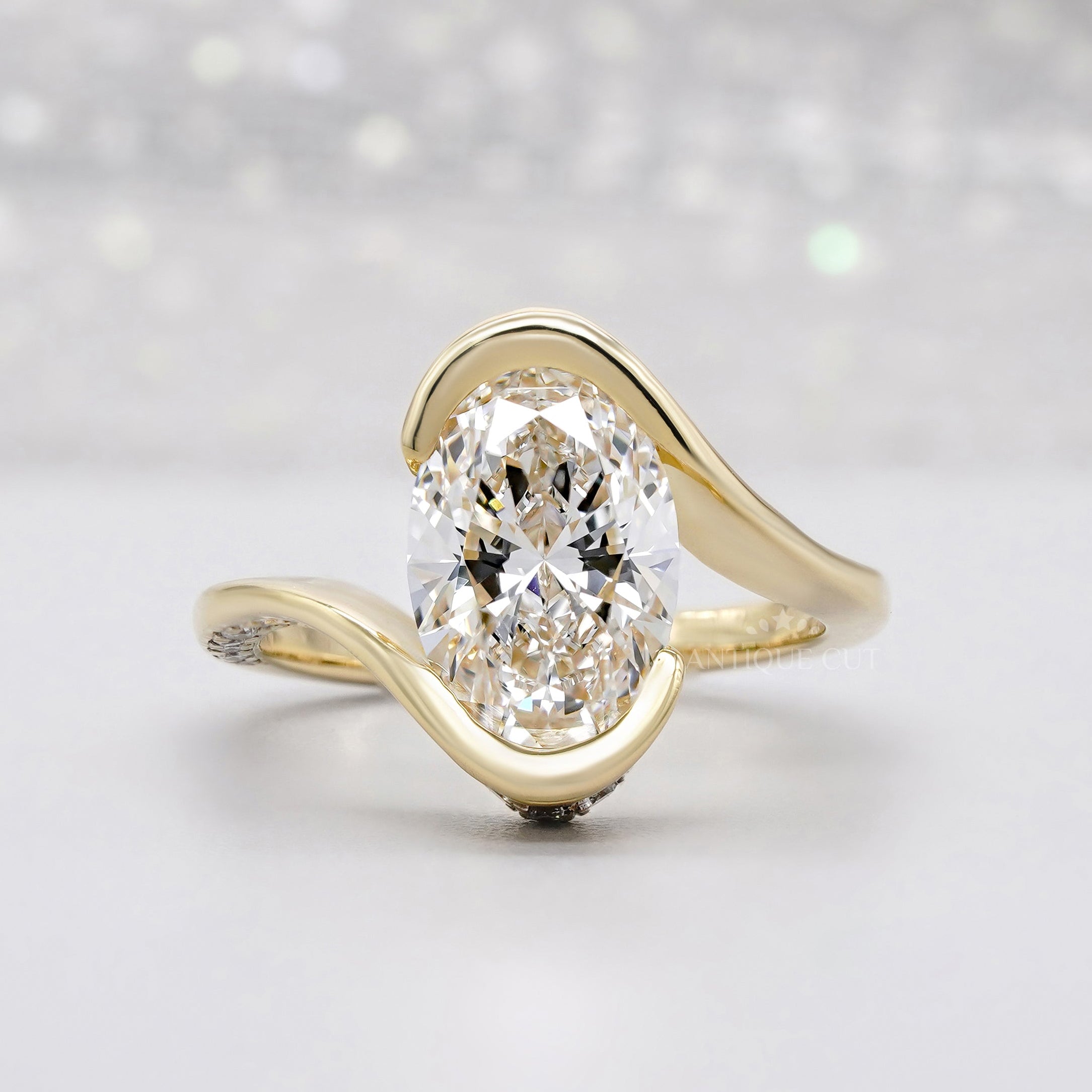 Bypass bezel set oval engagement ring in yellow gold