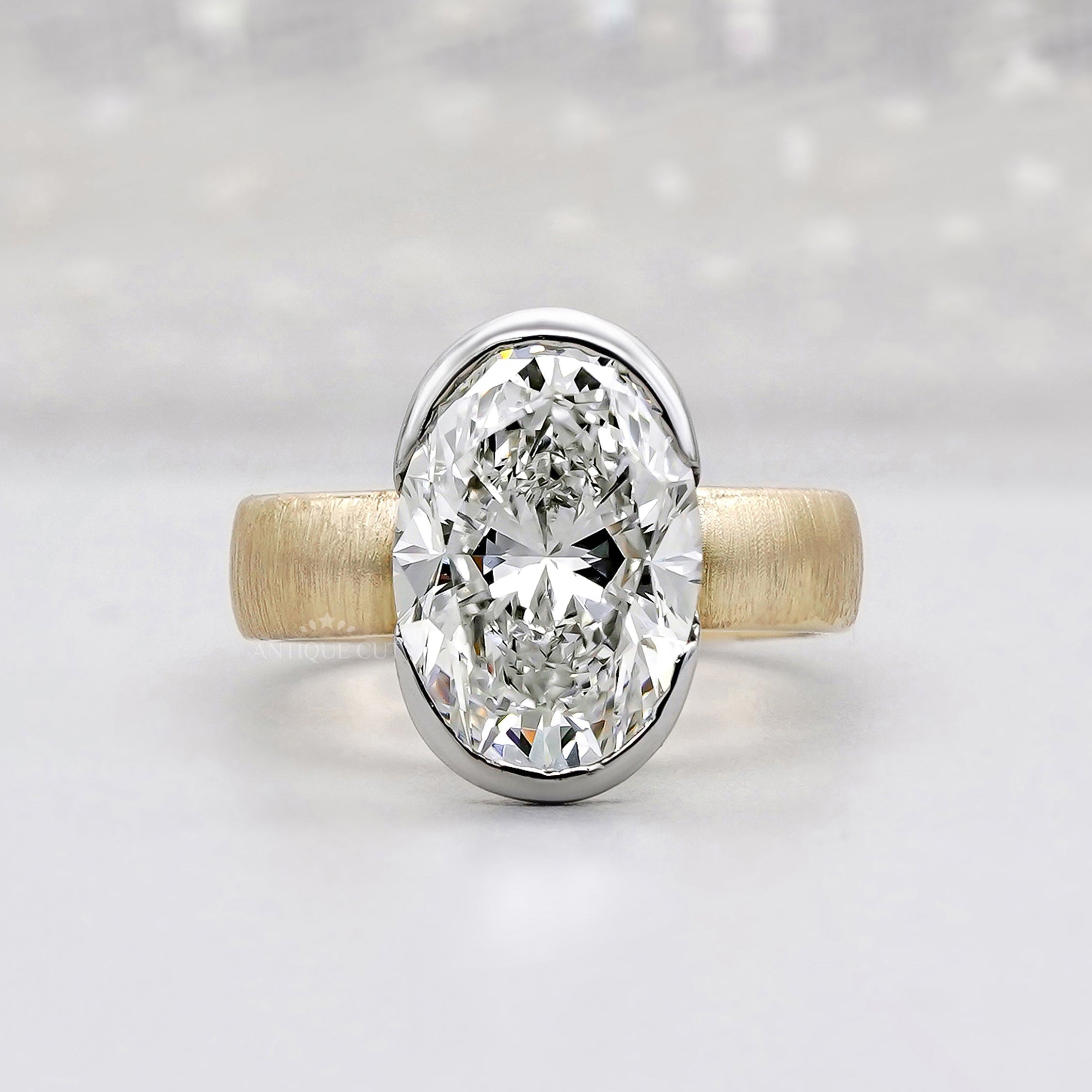 Bezel set oval engagement ring with solitaire diamond and matte finish